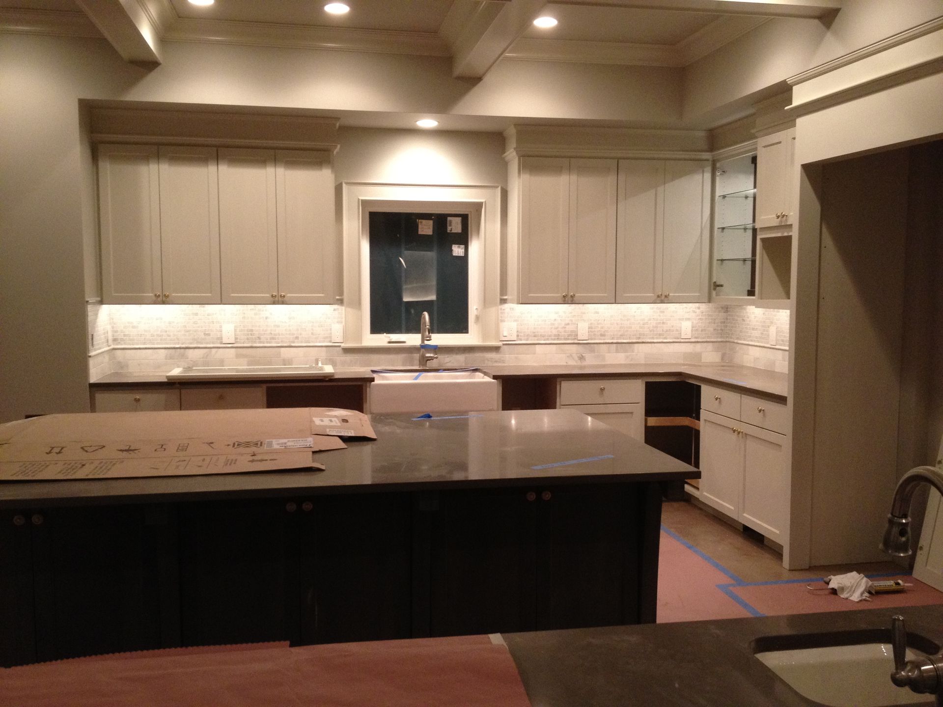 A kitchen with white cabinets and black counter tops