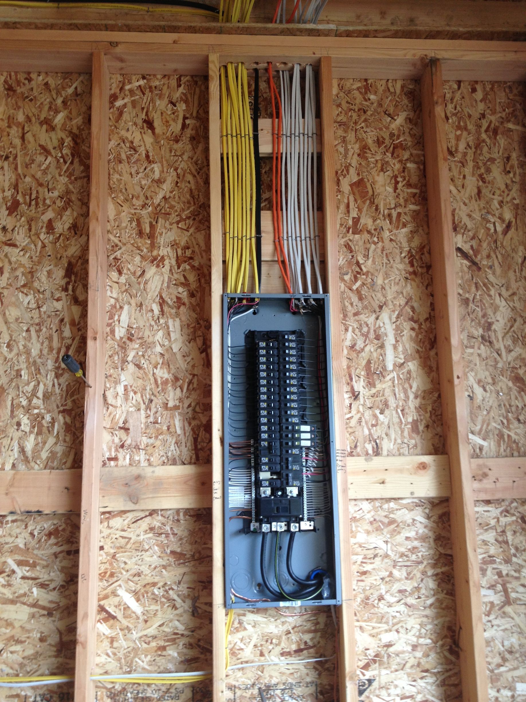 A wooden wall with electrical wires coming out of it.