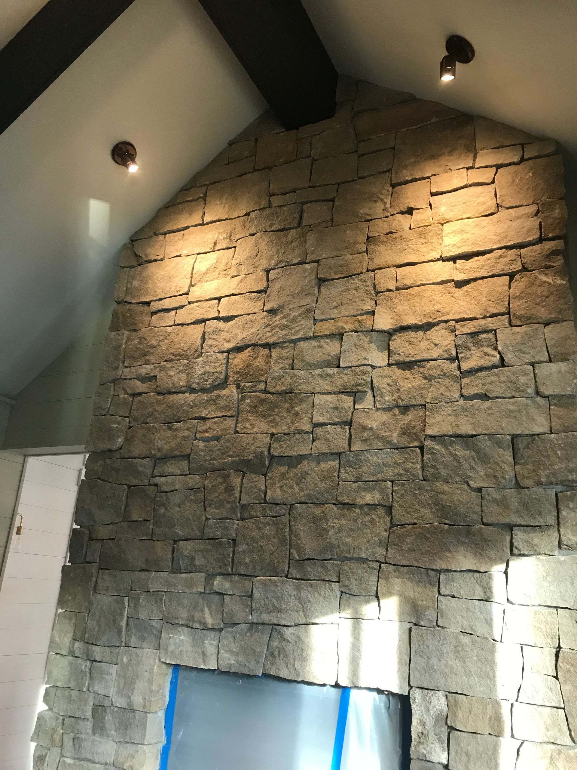 A stone wall with a fireplace in the middle of it