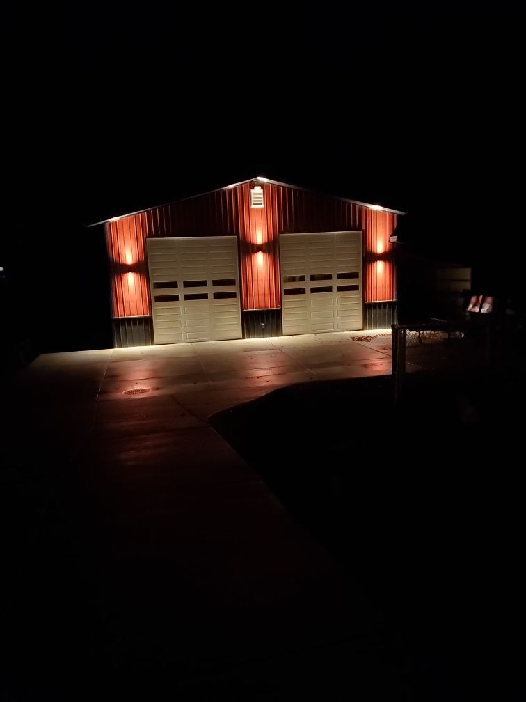 A garage is lit up at night with a lot of lights on it.