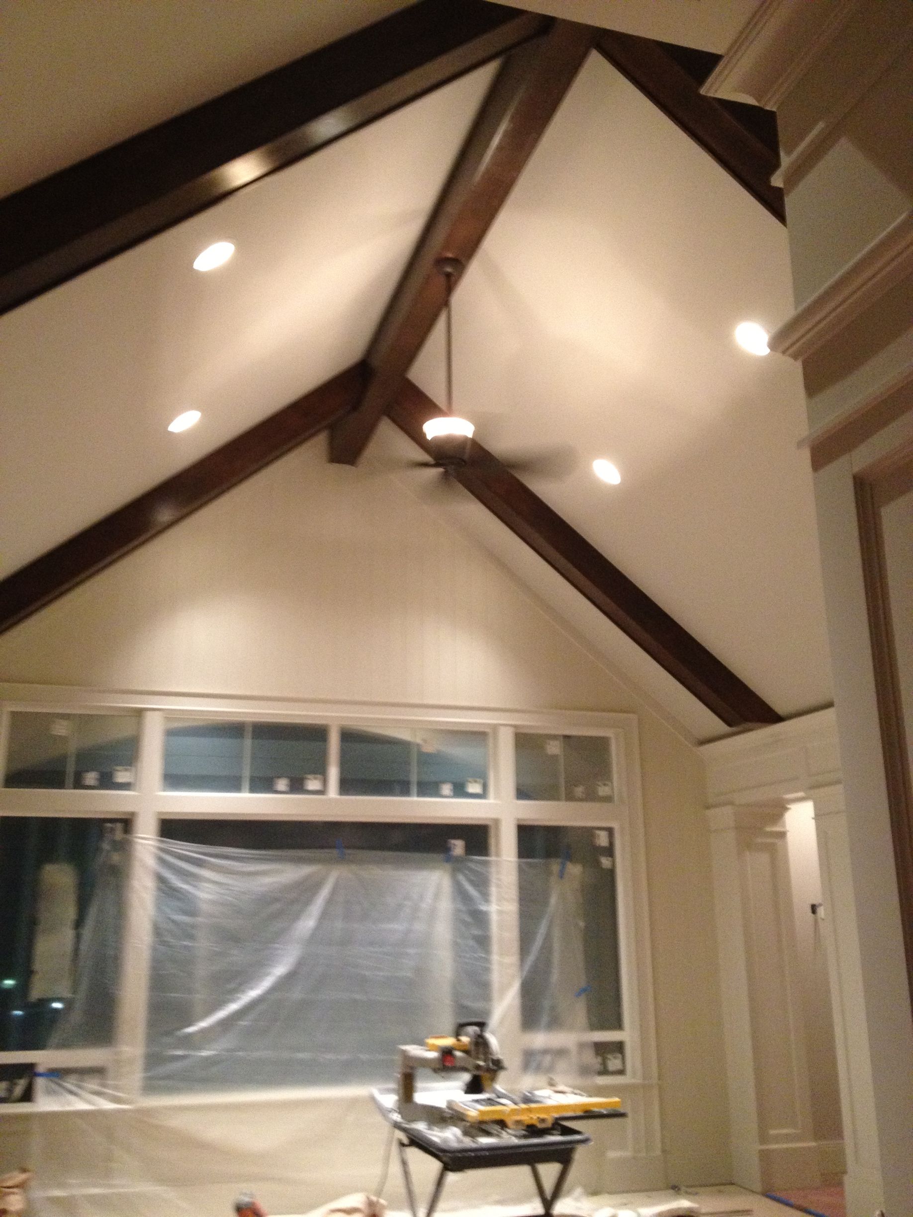 A room with a vaulted ceiling and a ceiling fan