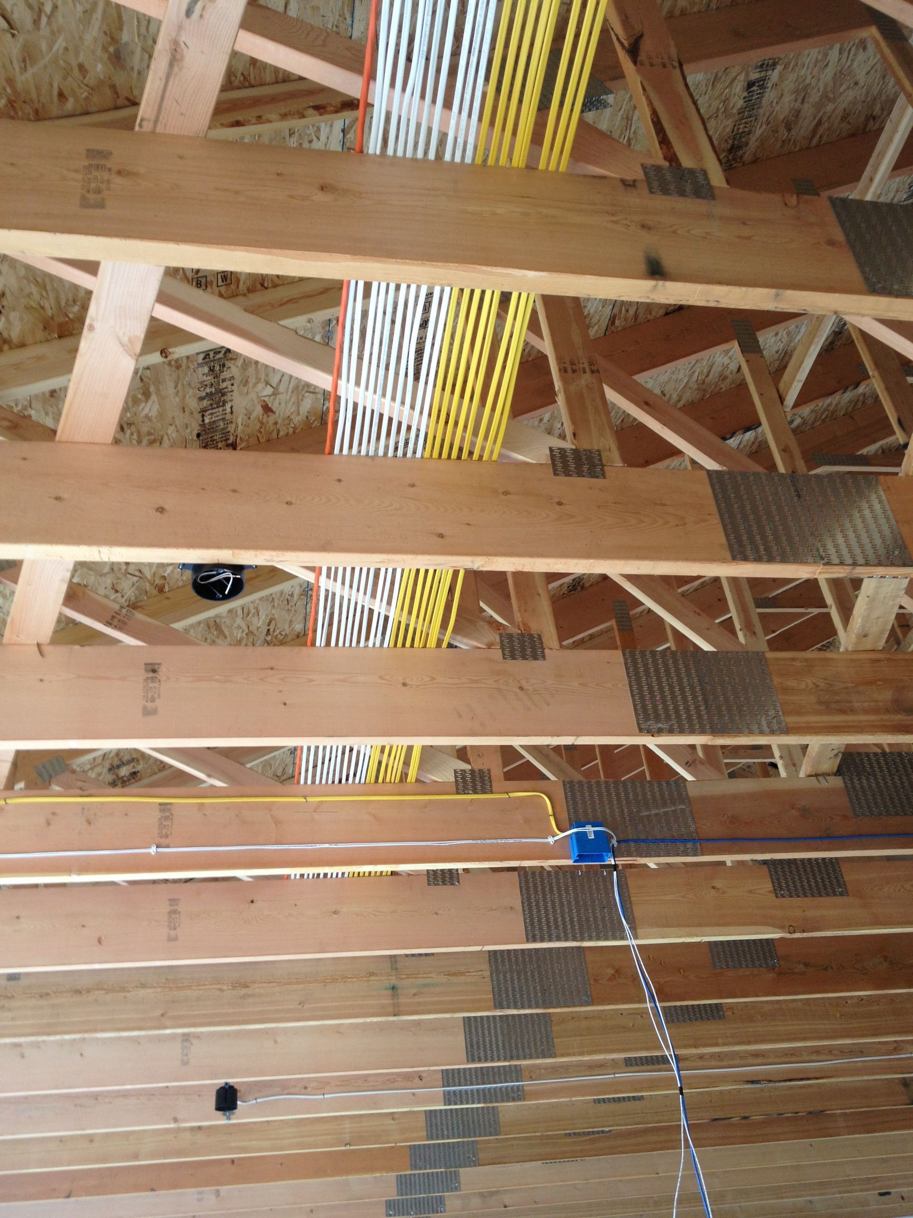 A wooden ceiling with a bunch of wires hanging from it