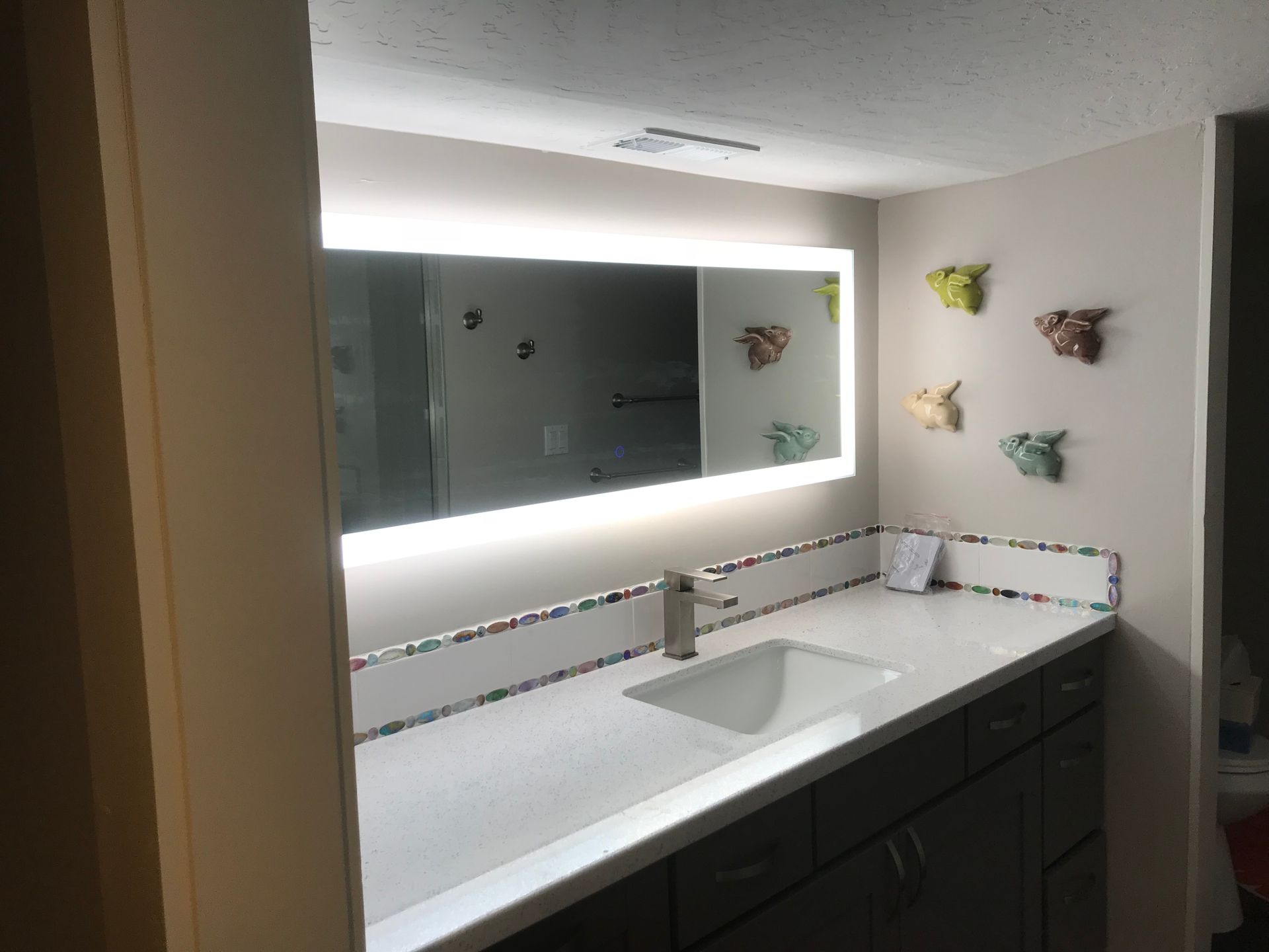 A bathroom with a sink and a large mirror