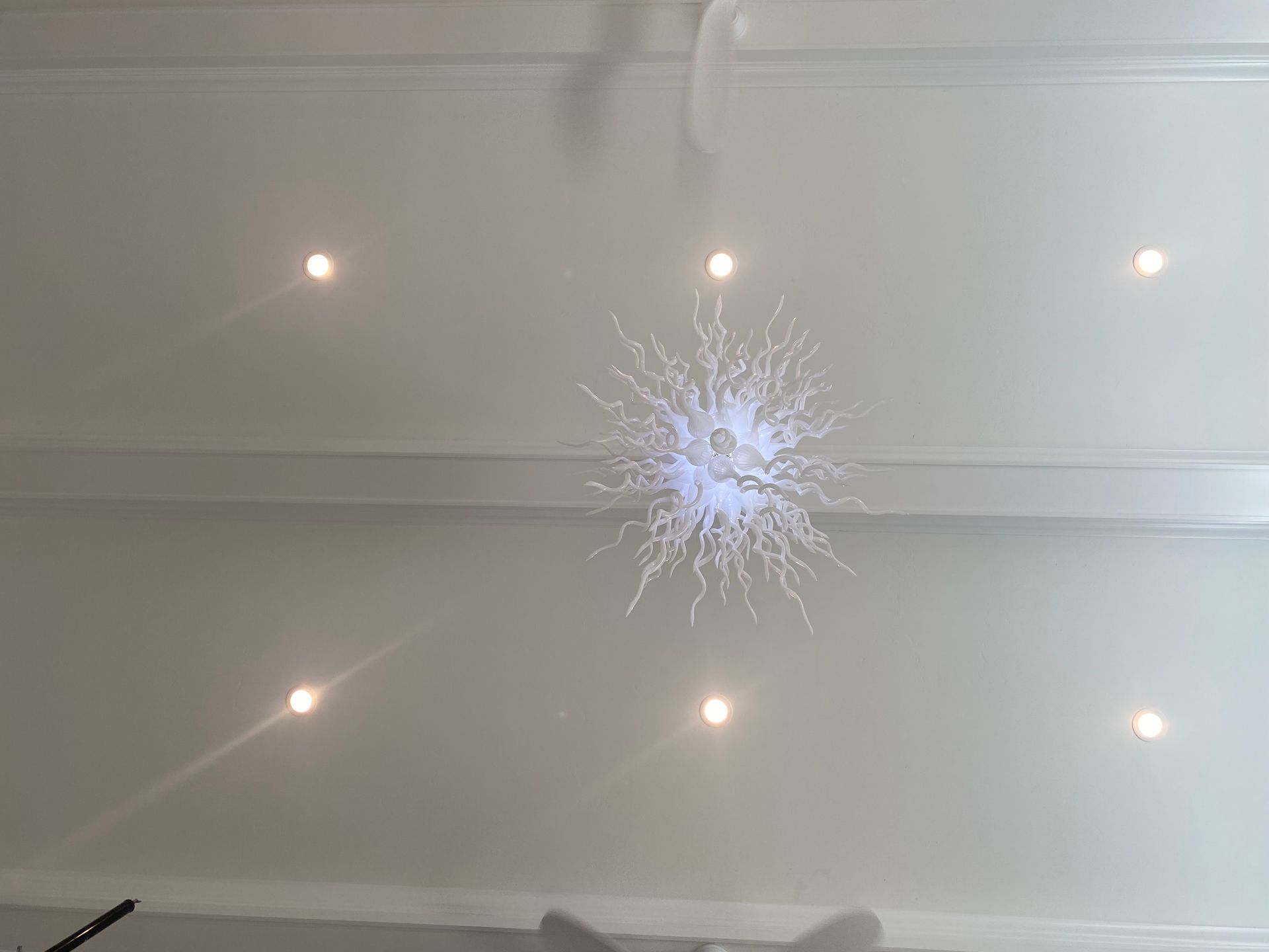 A white ceiling with a chandelier hanging from it.