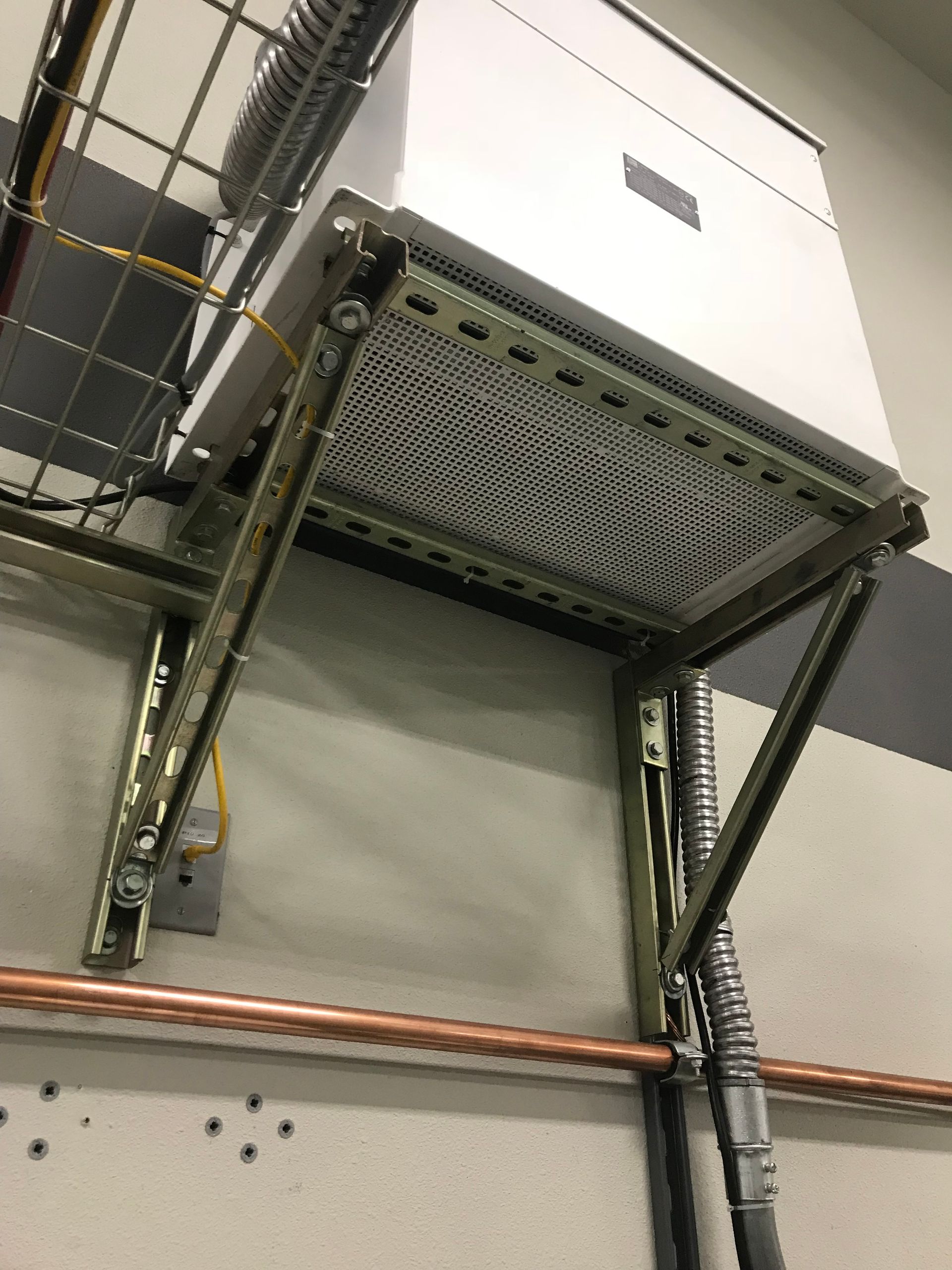 A white box is hanging from the ceiling of a building.