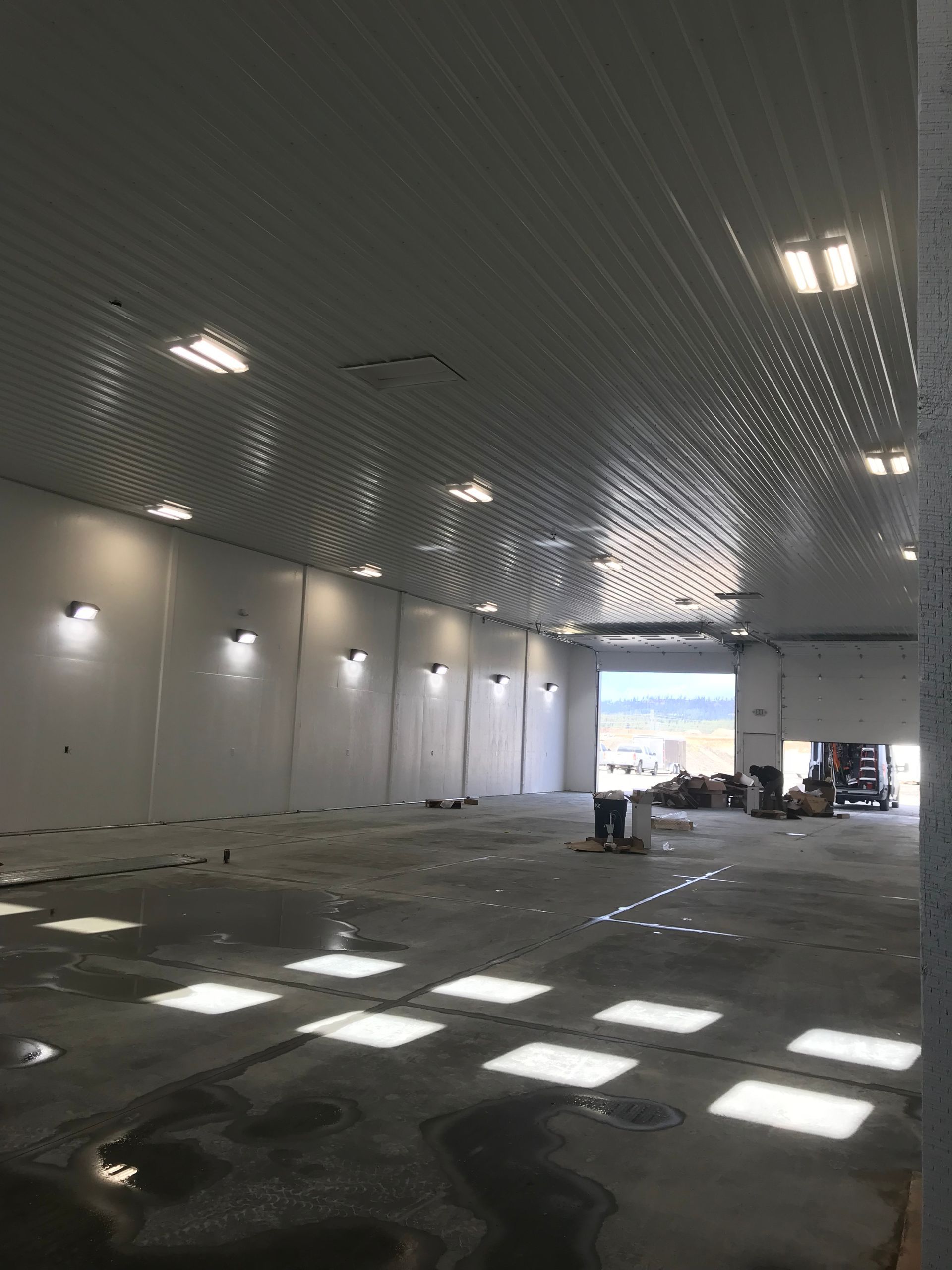 A large empty warehouse with a white ceiling and concrete floor.