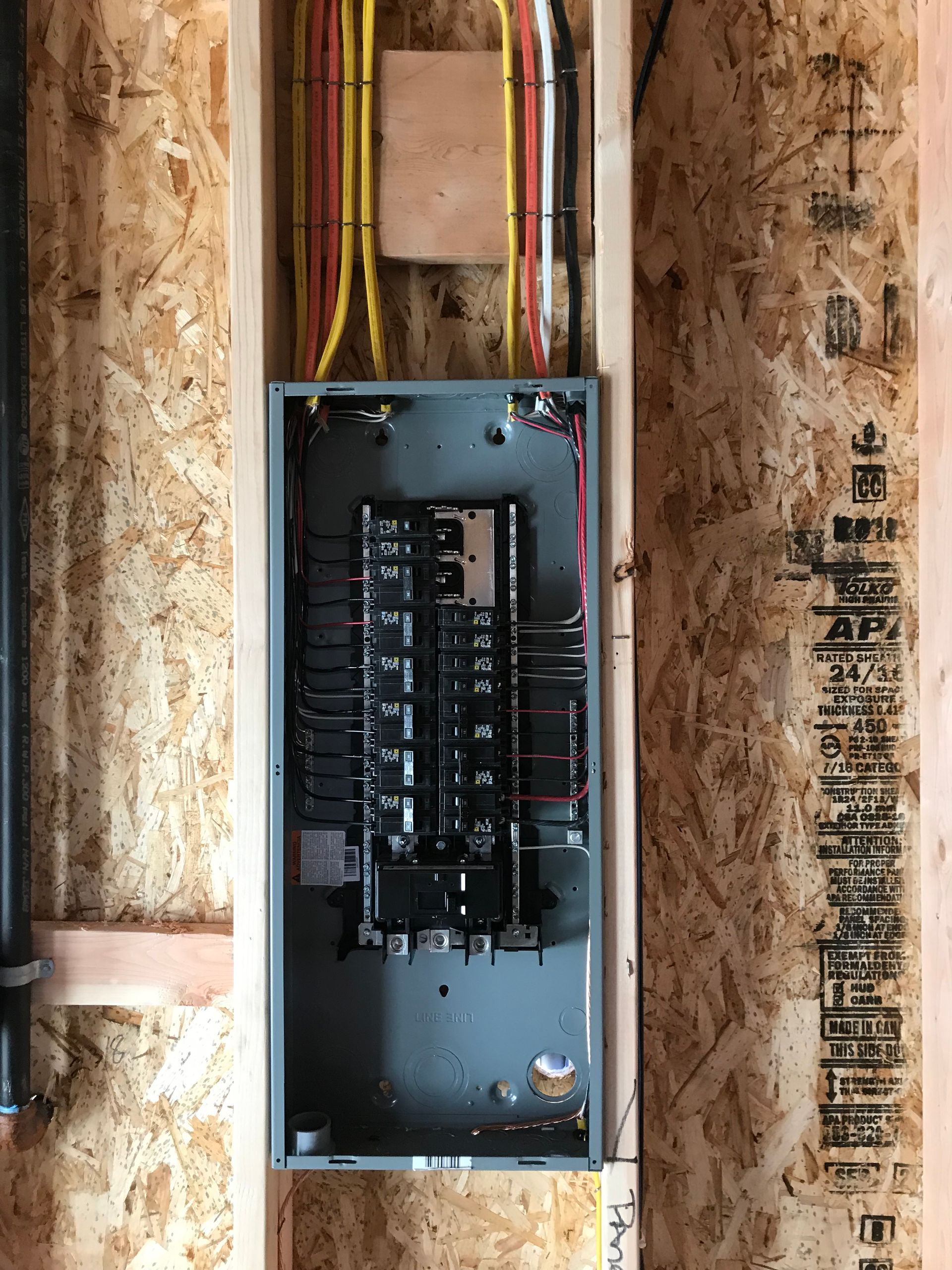 A electrical box is hanging on a wooden wall.