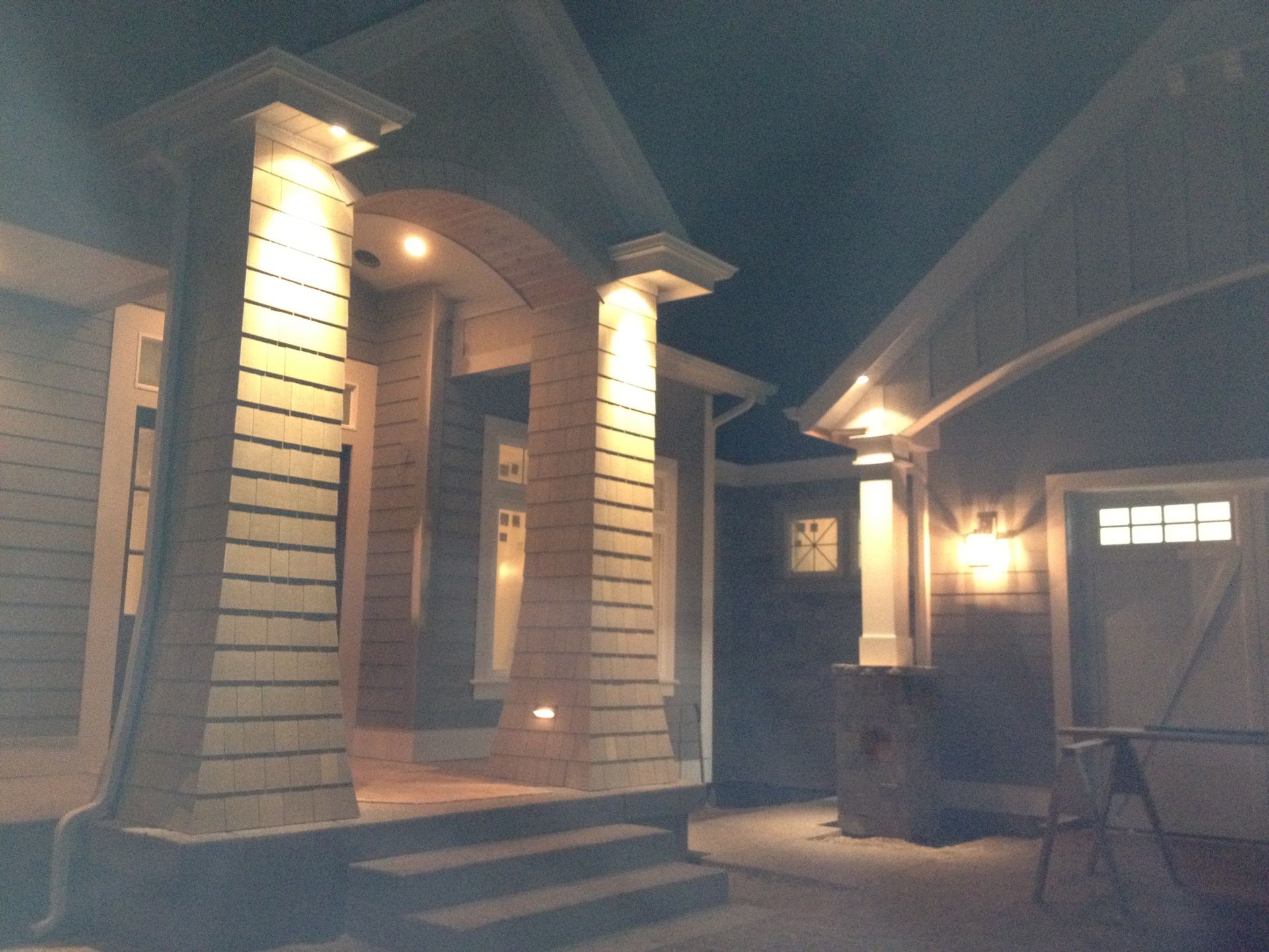 The front porch of a house is lit up at night