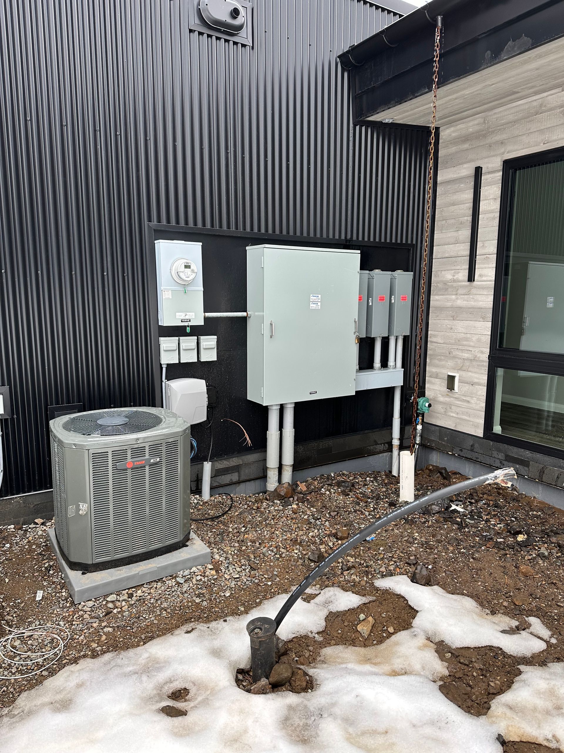A large air conditioner is sitting outside of a building.