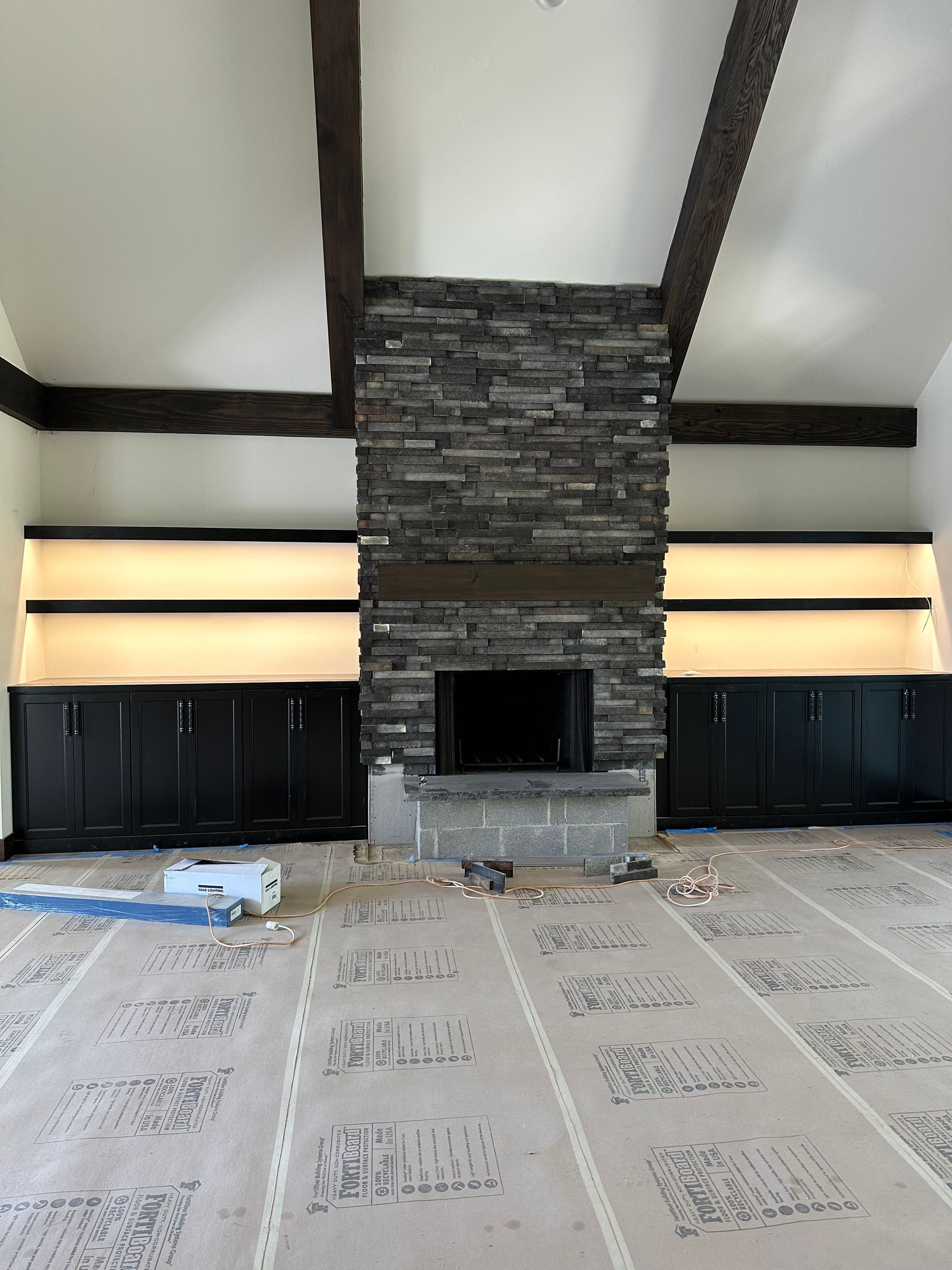 A living room with a fireplace and shelves in it