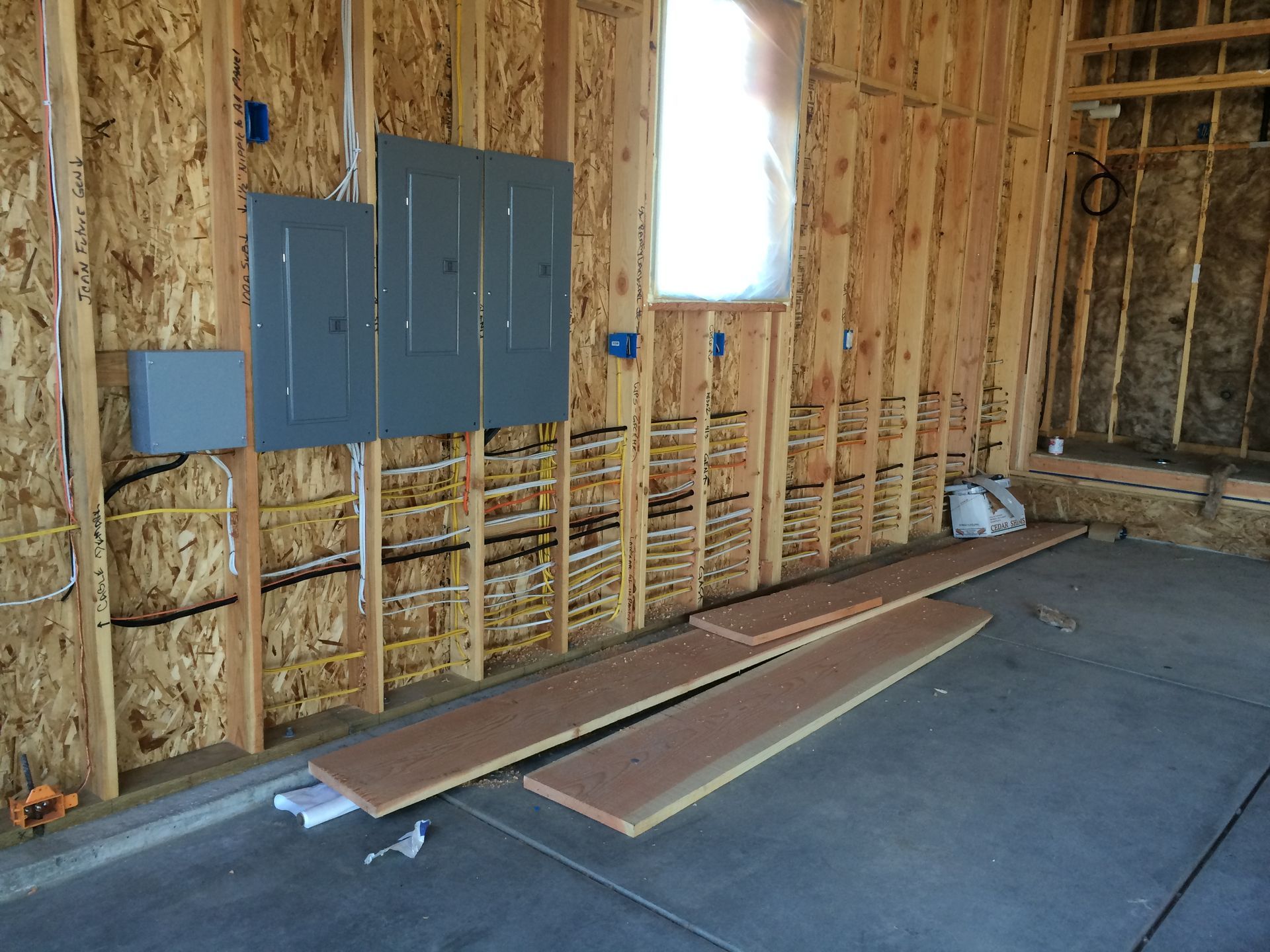 A wooden wall with electrical panels and a window