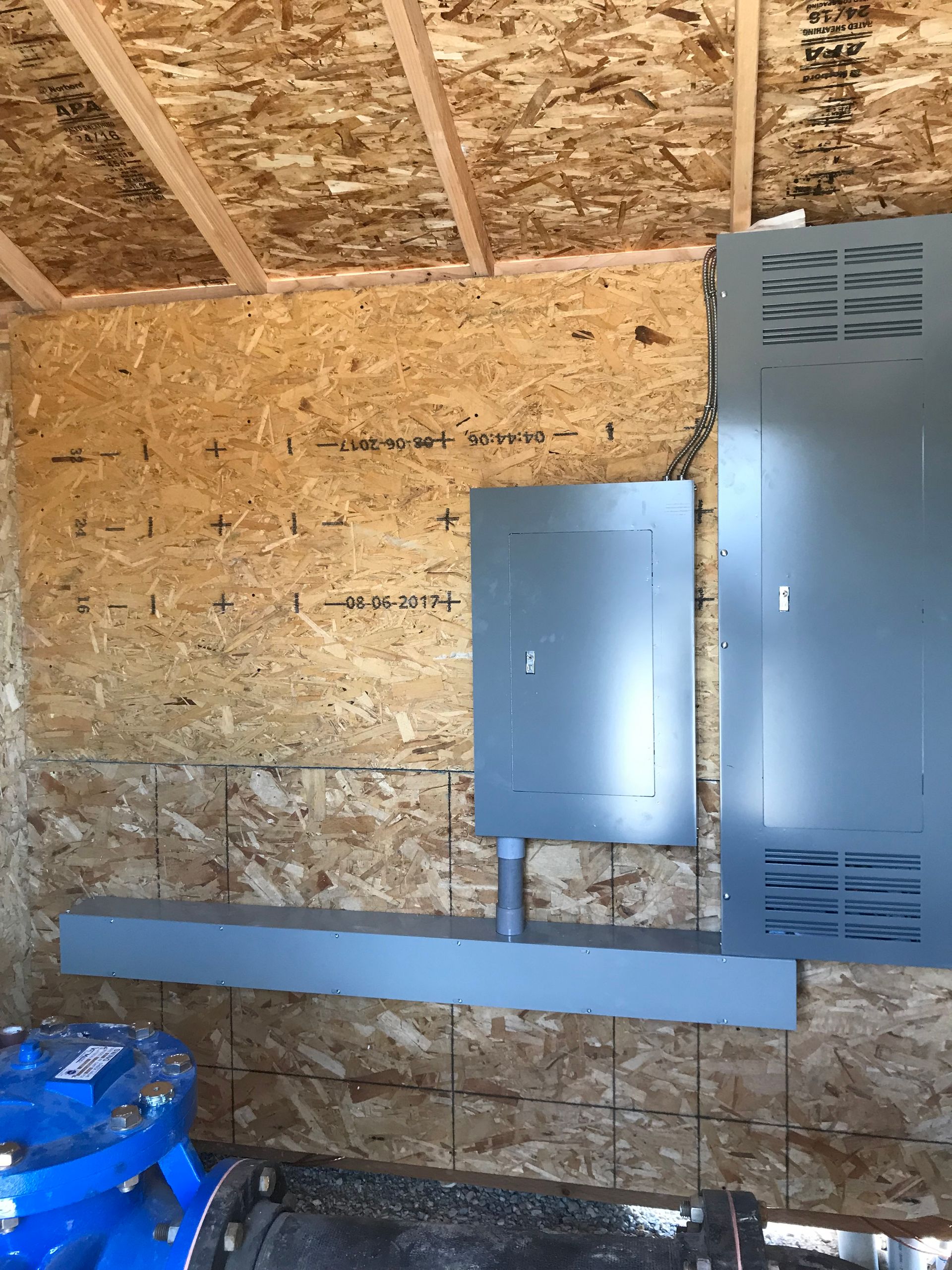 A building under construction with a electrical box on the wall