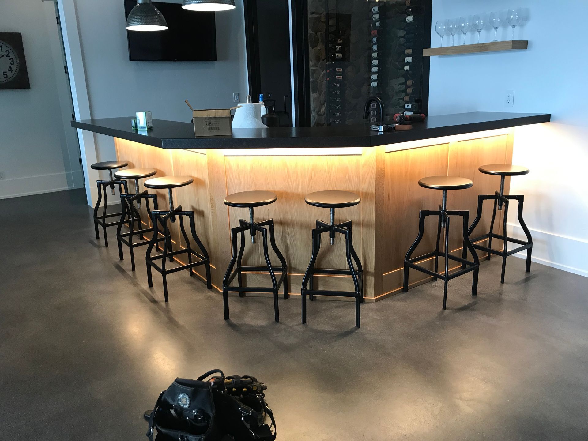 A bar with stools and a clock on the wall