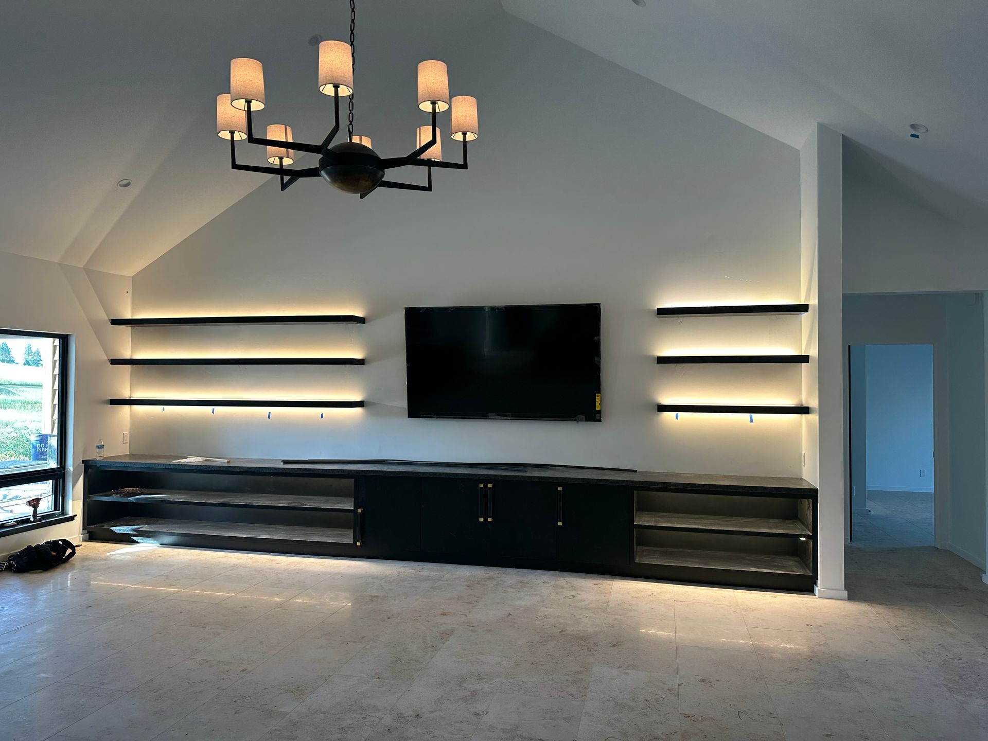 A living room with a flat screen tv and a chandelier