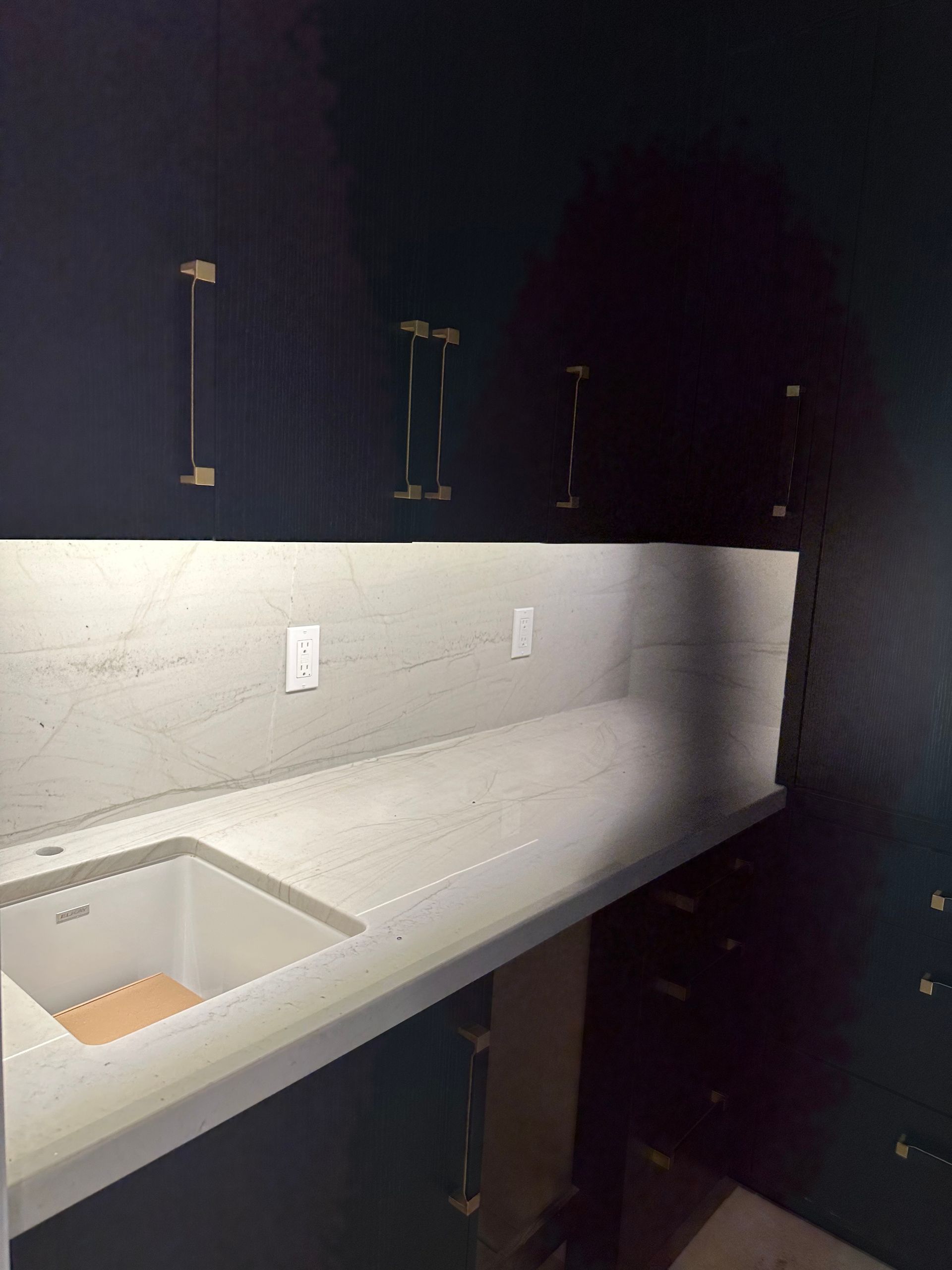 A kitchen with black cabinets and a sink