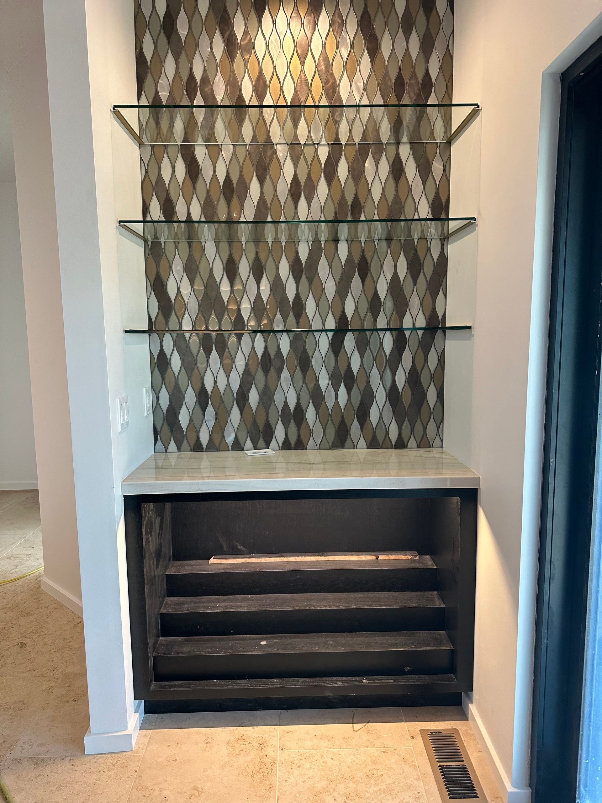 A room with a shelf and stairs in it