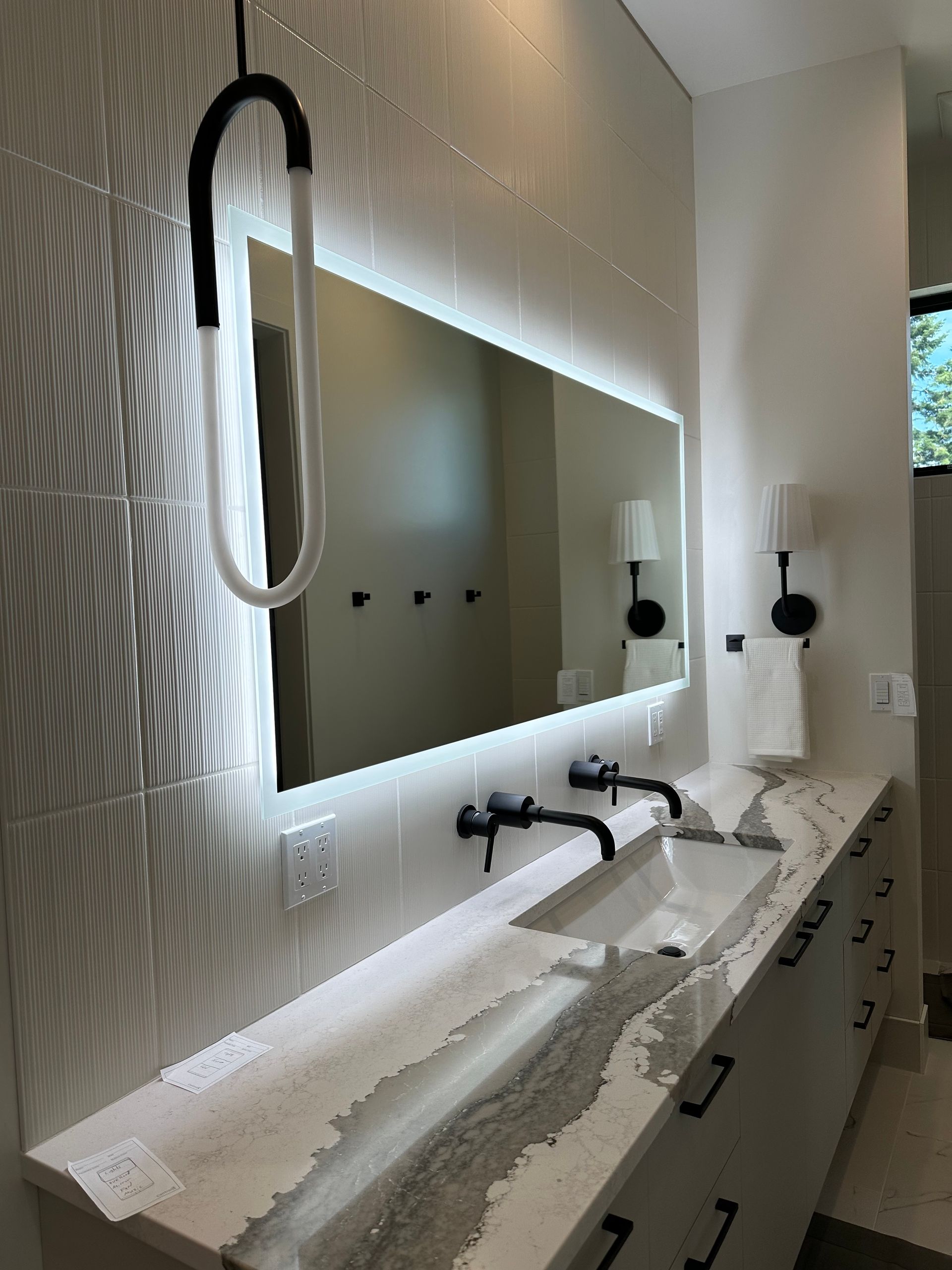 A bathroom with two sinks and a large mirror.