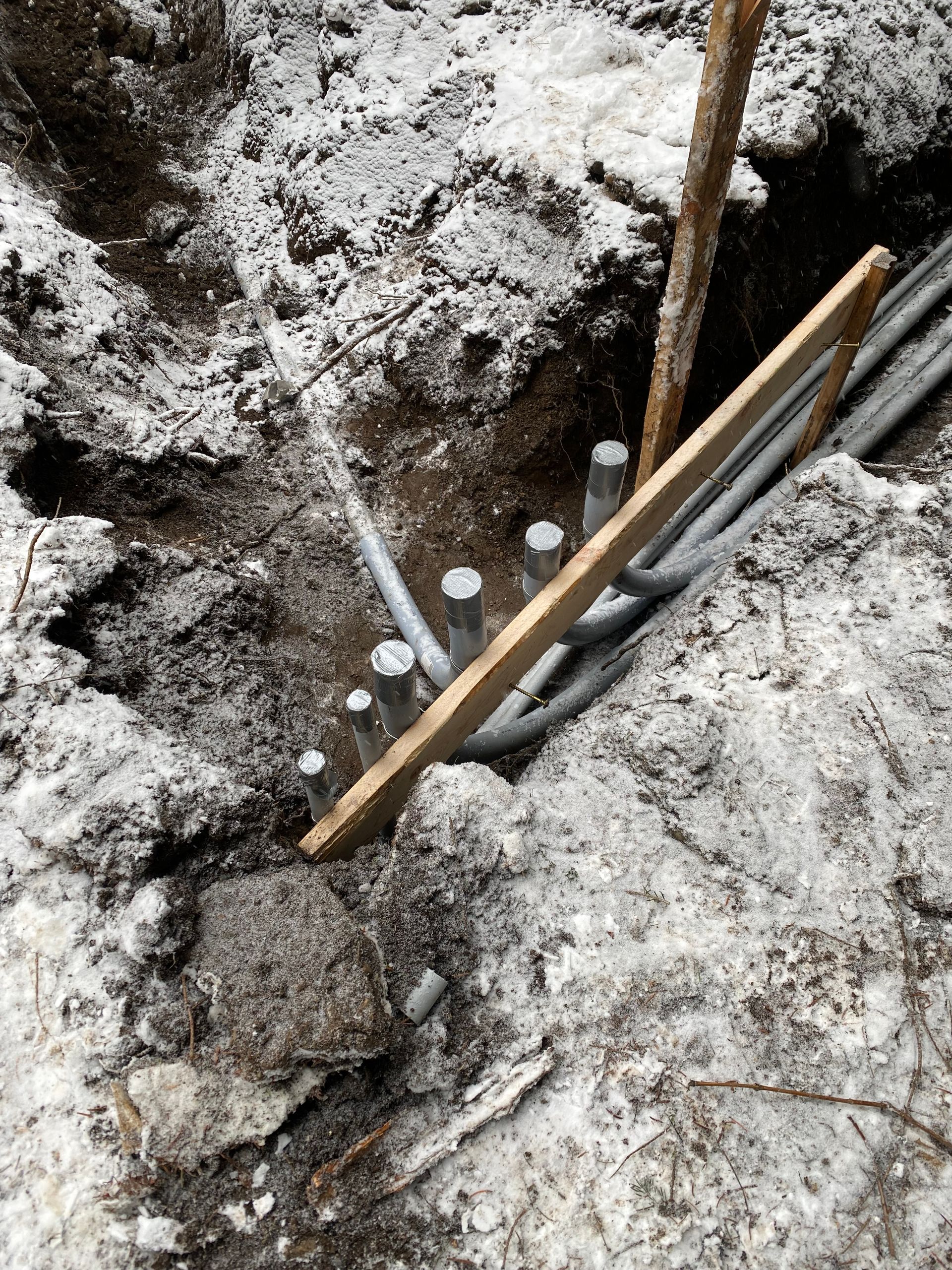 A wooden stick is sticking out of a hole in the ground.