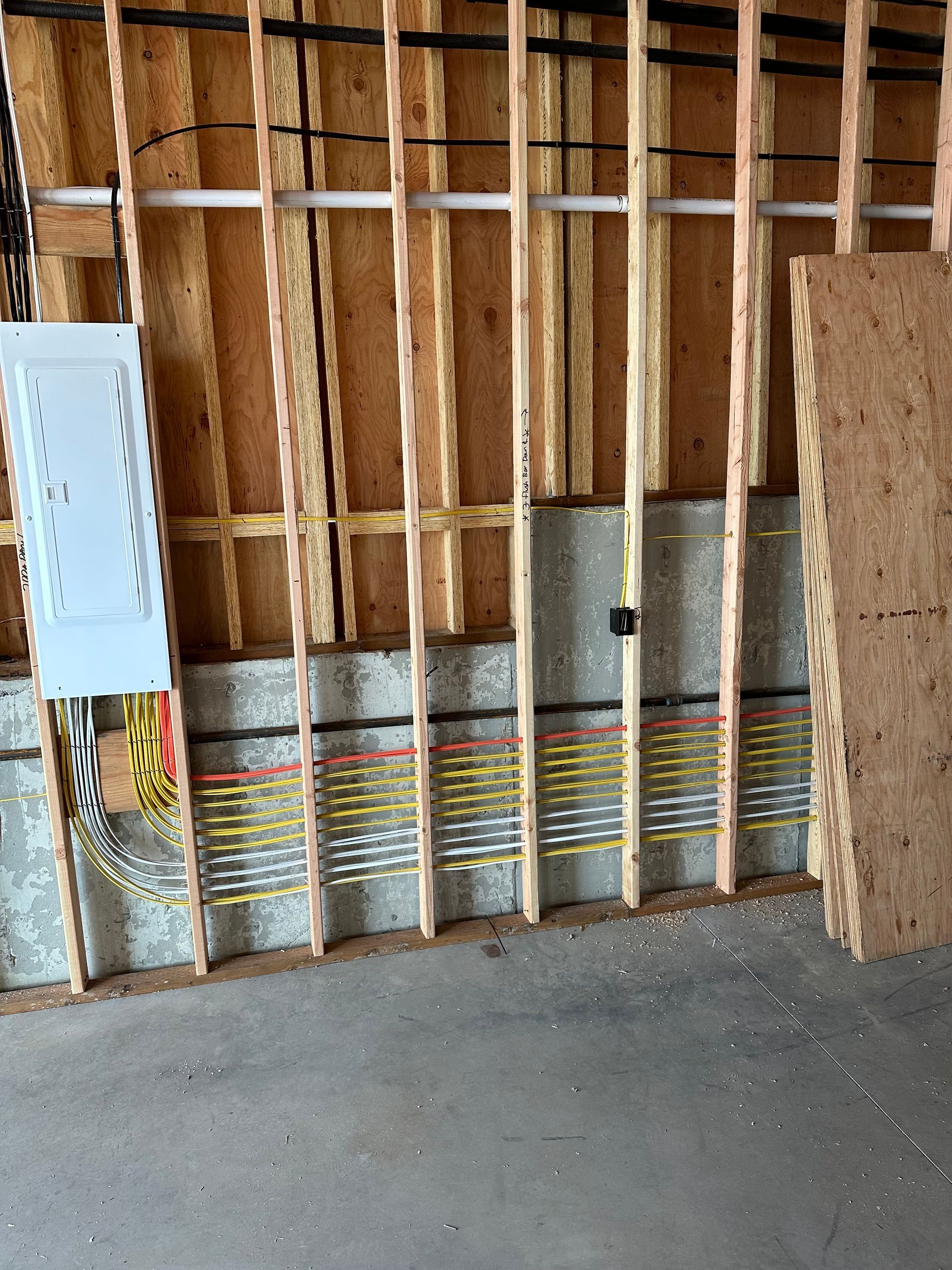 A wooden wall with electrical wires coming out of it.