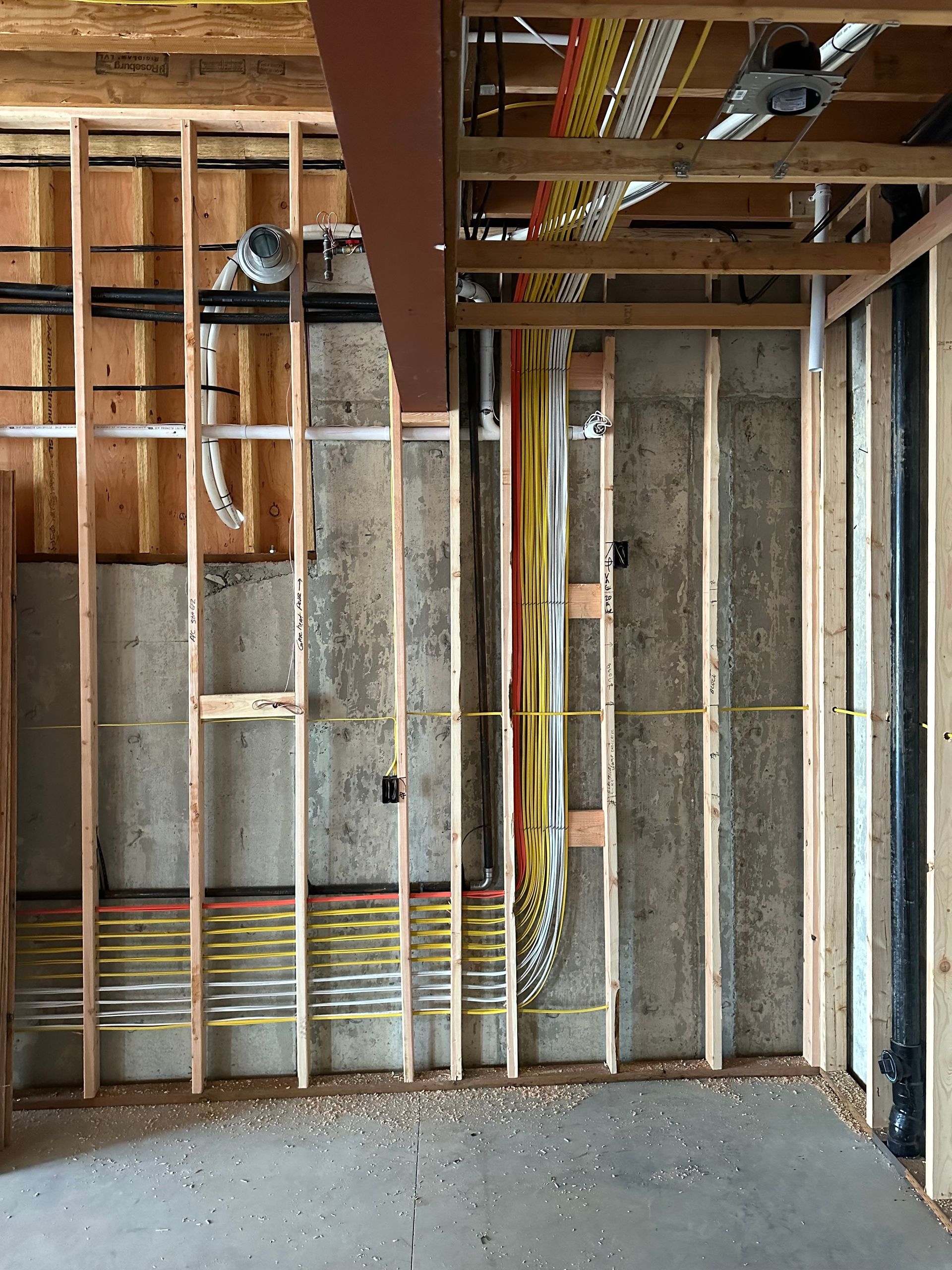 A room with a concrete wall and wooden beams.