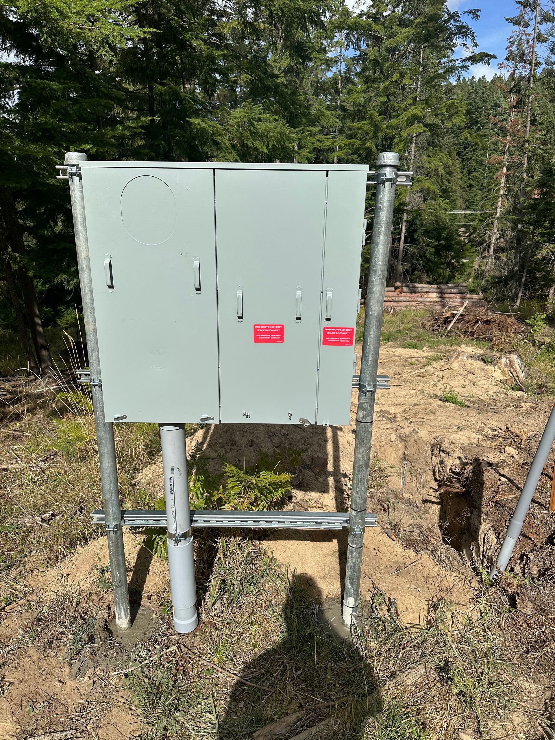 A large box is sitting on top of a metal pole in the middle of a field.