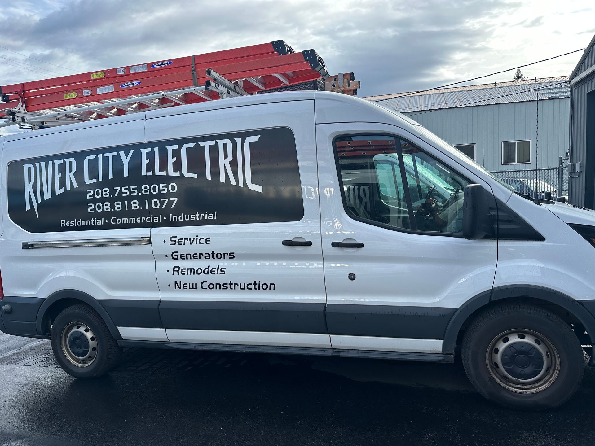 A river city electric van is parked in front of a building
