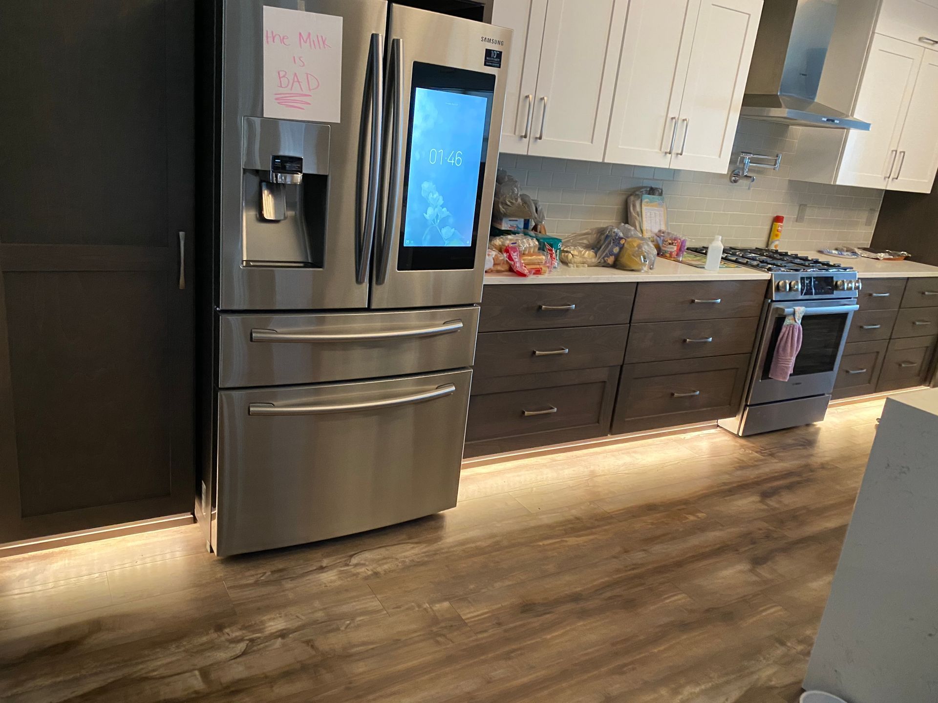 A kitchen with stainless steel appliances and wooden floors.