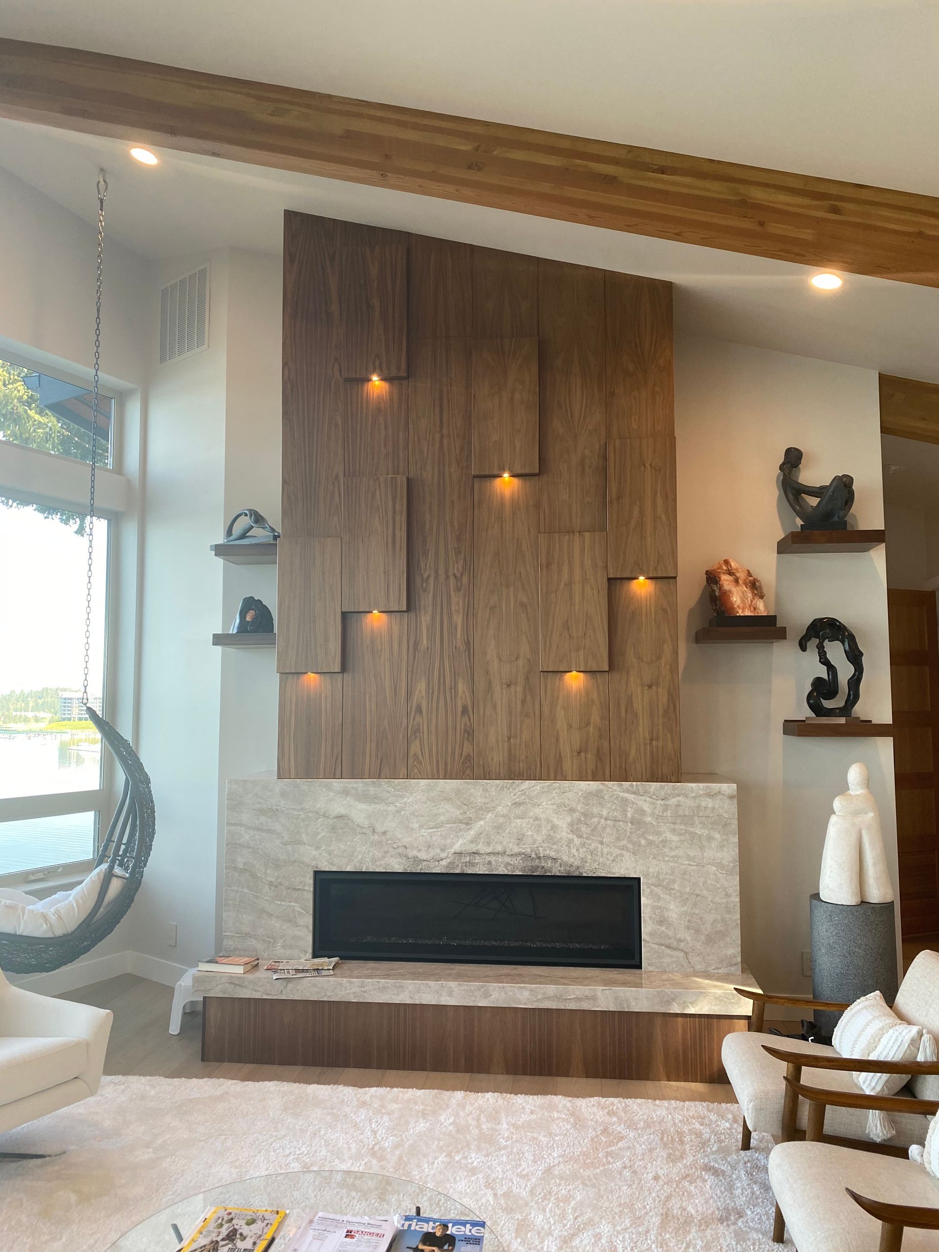 A living room with a fireplace and a wooden wall.