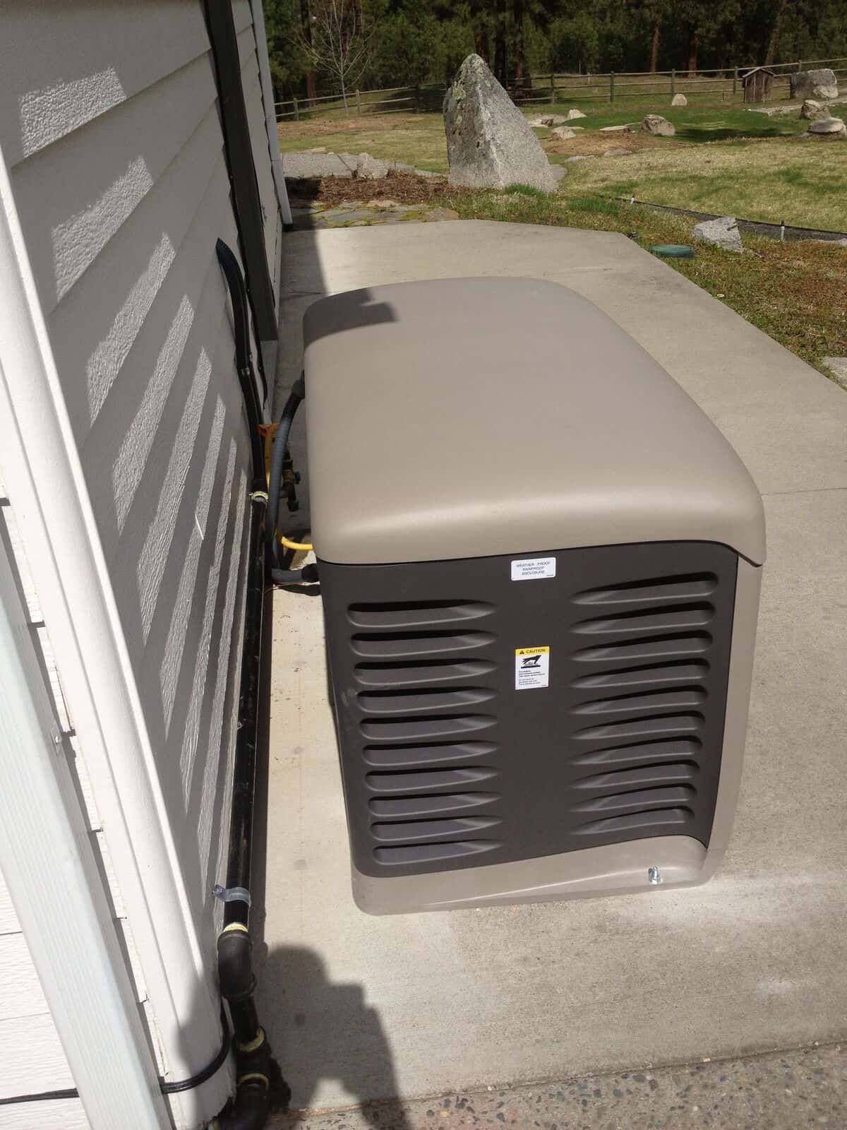 A generator is sitting on the side of a house.