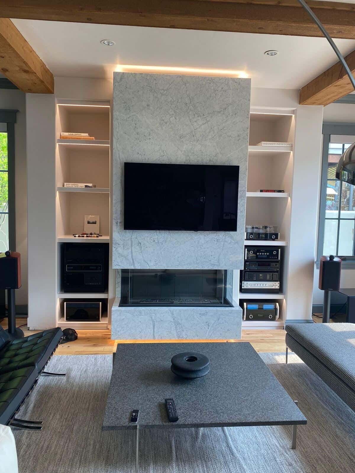 A living room with a fireplace and a flat screen tv on the wall.