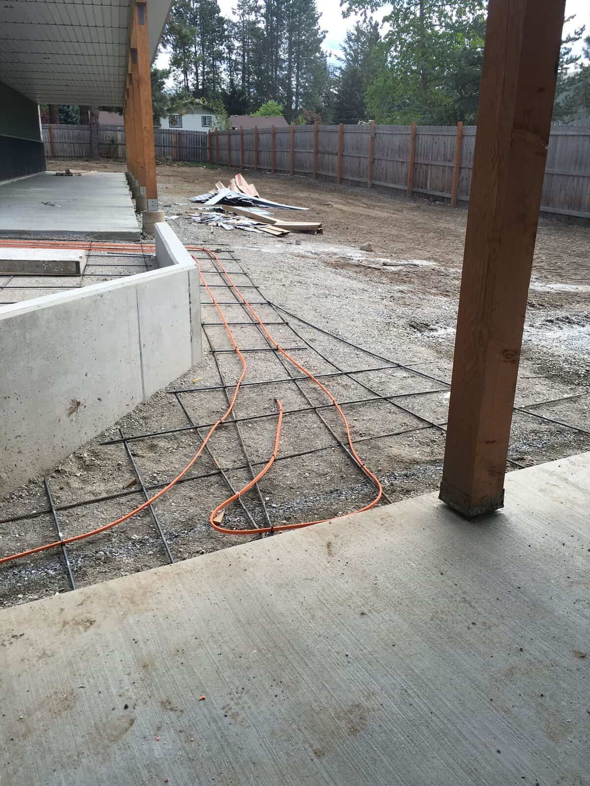 A concrete walkway is being built in a backyard.