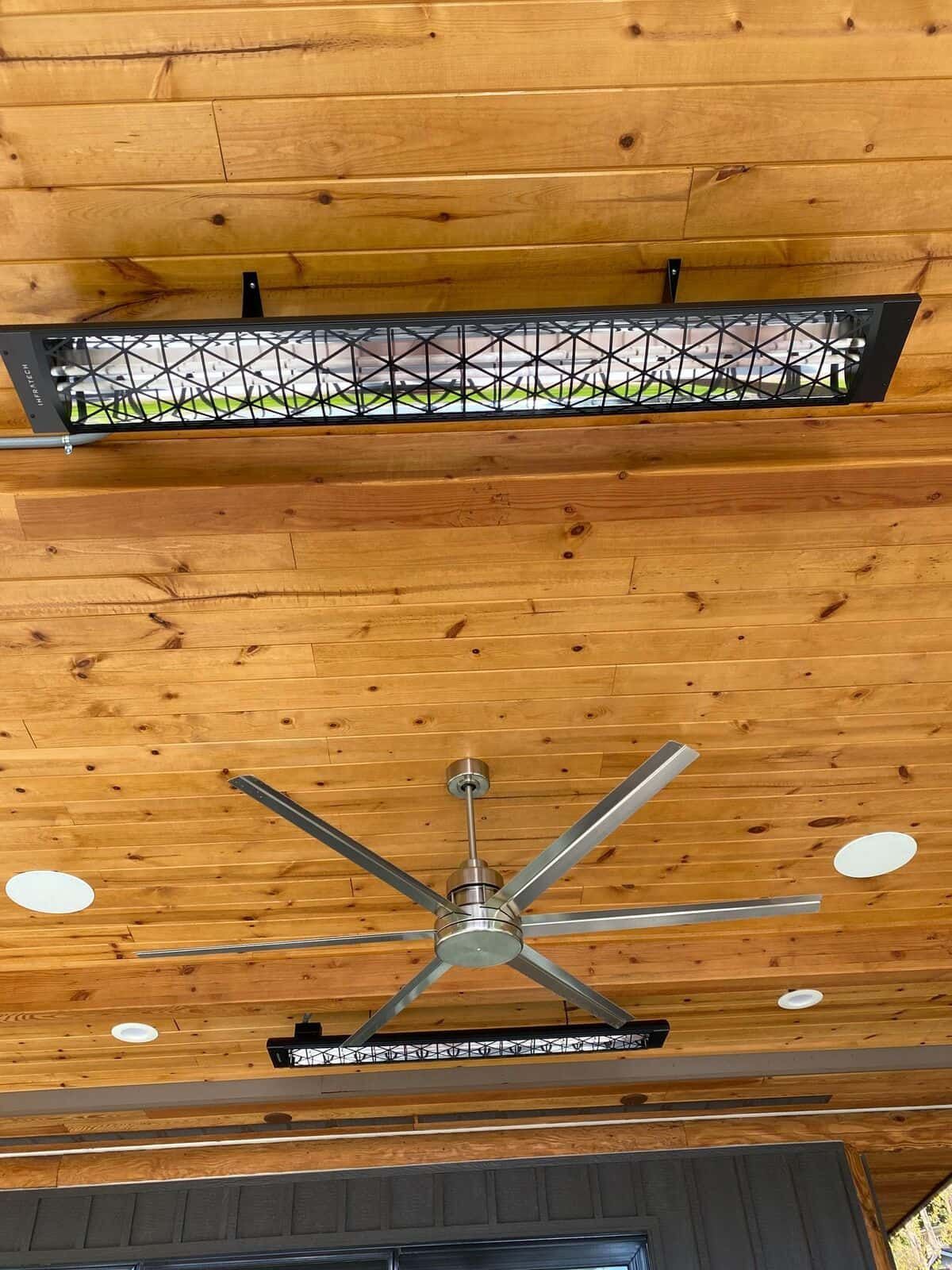 A ceiling fan is hanging from the ceiling of a wooden room.