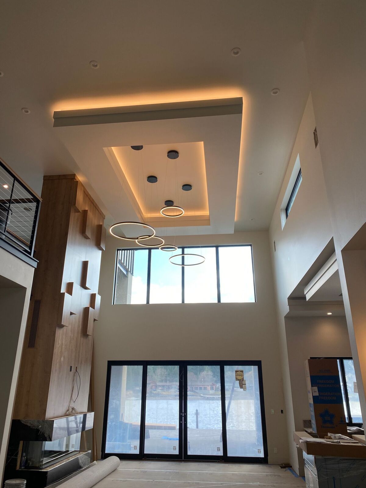 A living room with a lot of windows and a ceiling that is very high.
