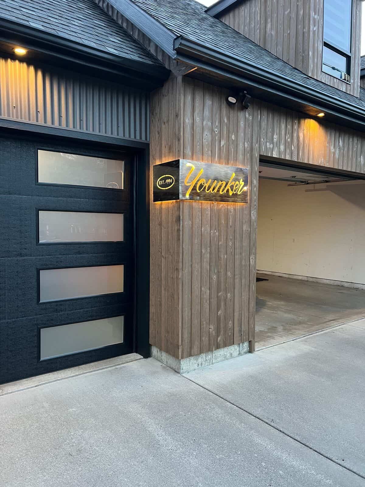 A house with a garage door and a sign on the side of it.