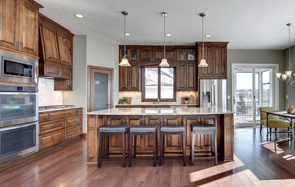 a kitchen with wooden cabinets and stainless steel appliances and a large island