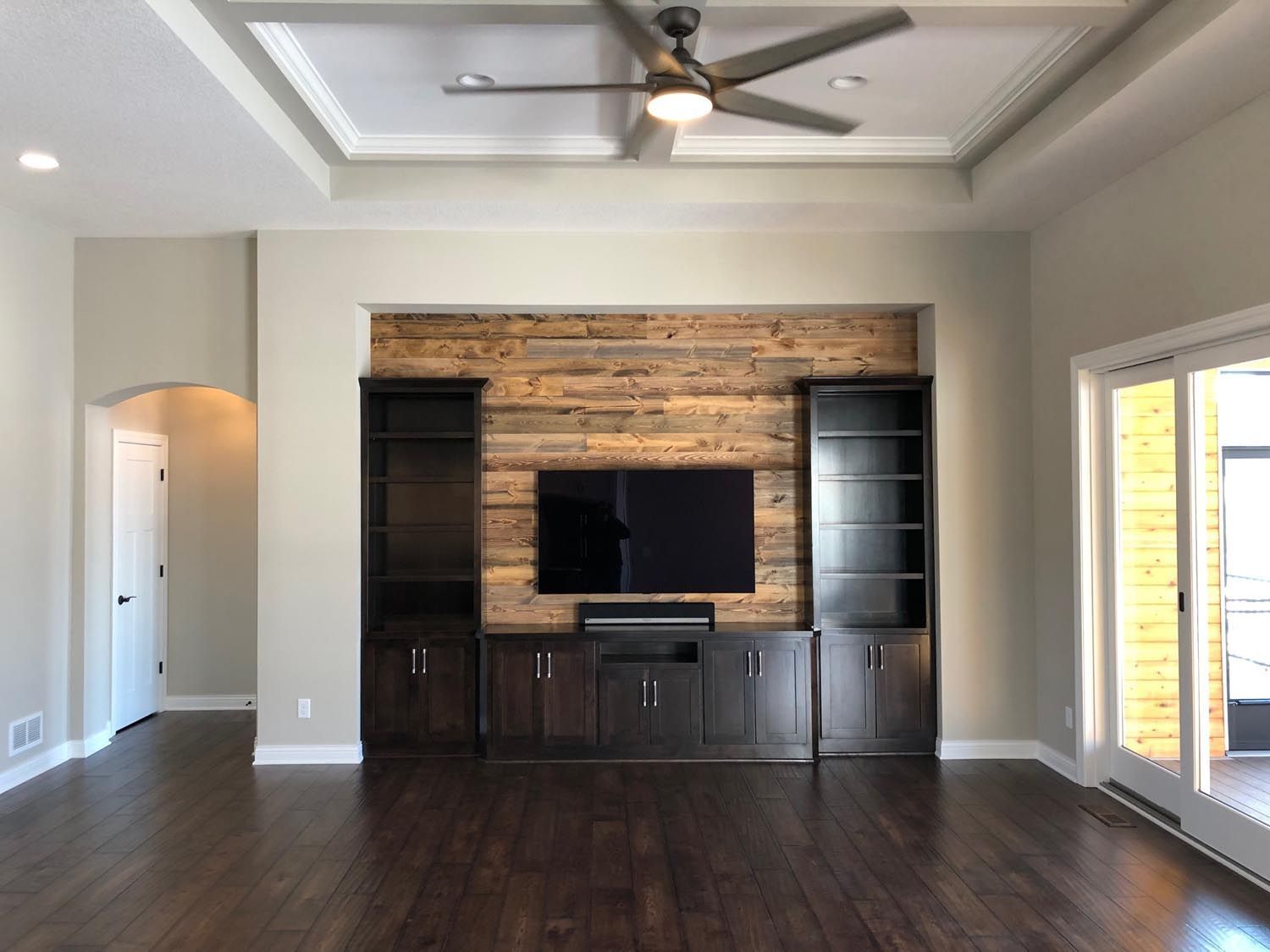 a living room with a ceiling fan and a flat screen tv