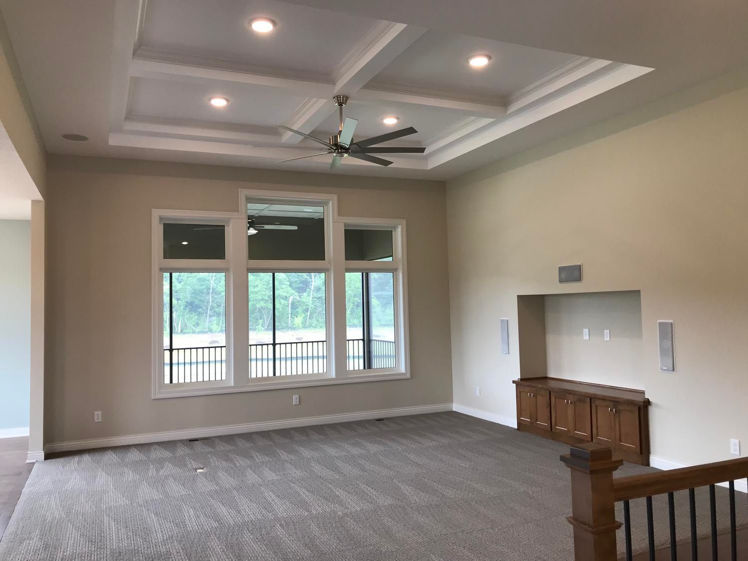 an empty living room with a ceiling fan and a lot of windows