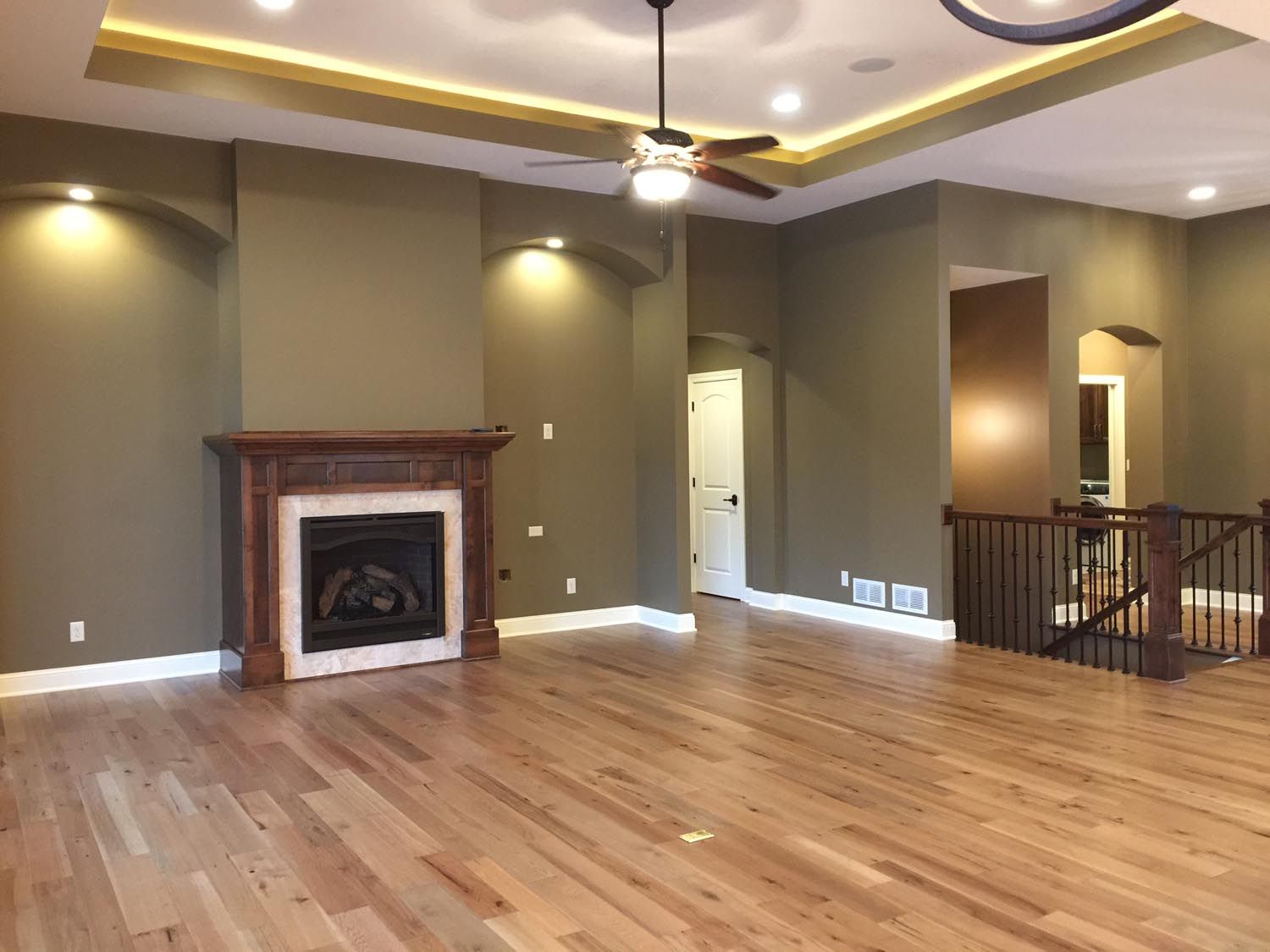 an empty living room with hardwood floors and a fireplace