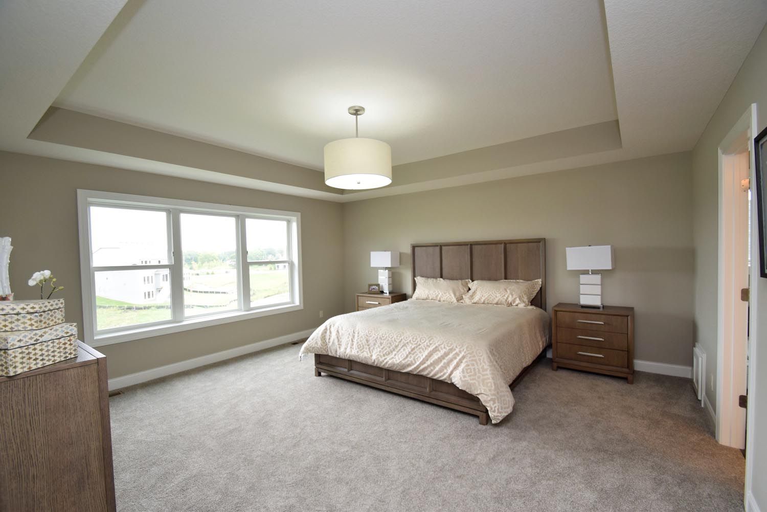 a bedroom with a large bed and a lot of windows