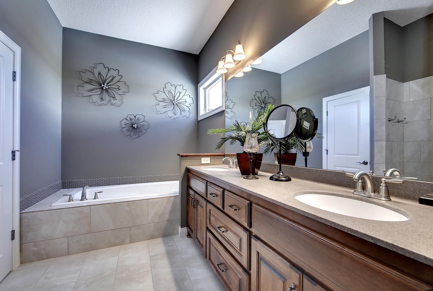 a bathroom with two sinks, a tub and a large mirror