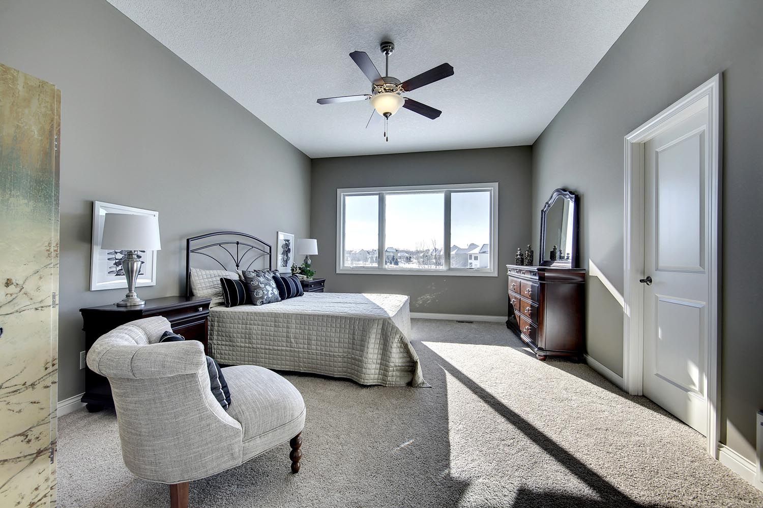 a bedroom with a large bed and a ceiling fan