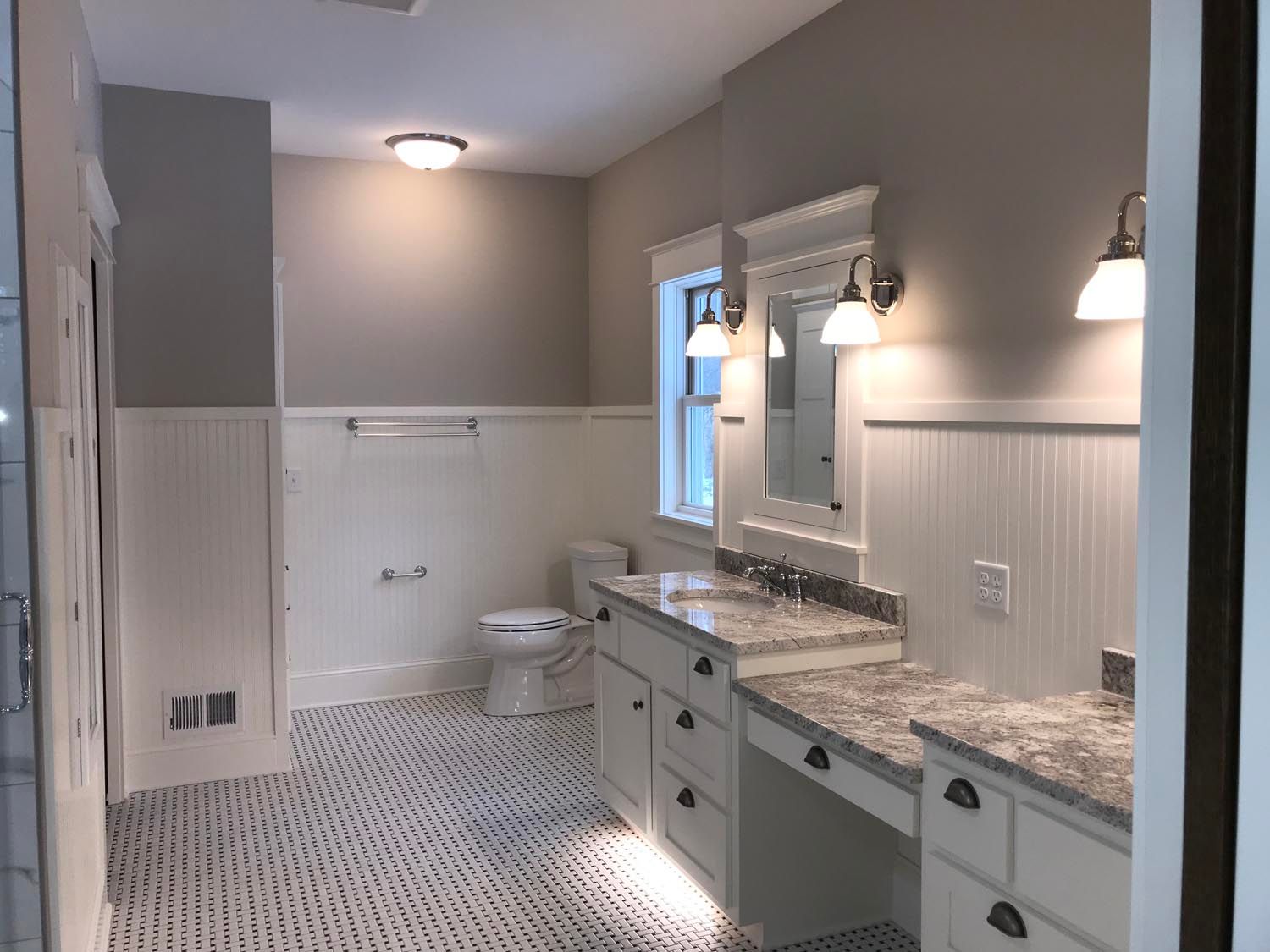 a bathroom with two sinks, a toilet, and a mirror