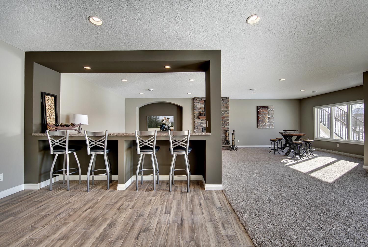 a large room with a bar and stools in it