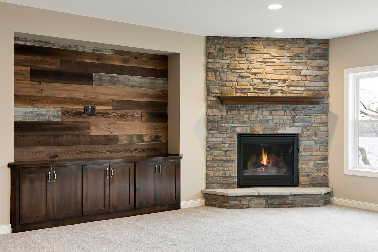 a living room with a fireplace and a wooden wall