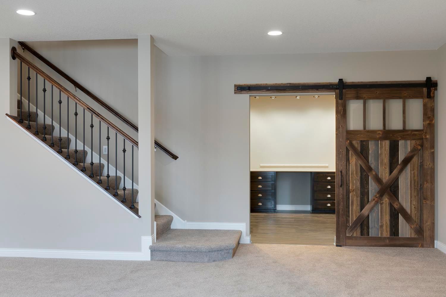 a basement with a staircase and a sliding barn door