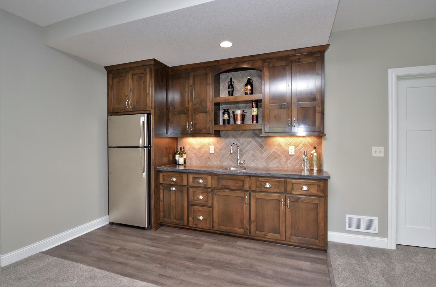a kitchen with wooden cabinets and a stainless steel refrigerator