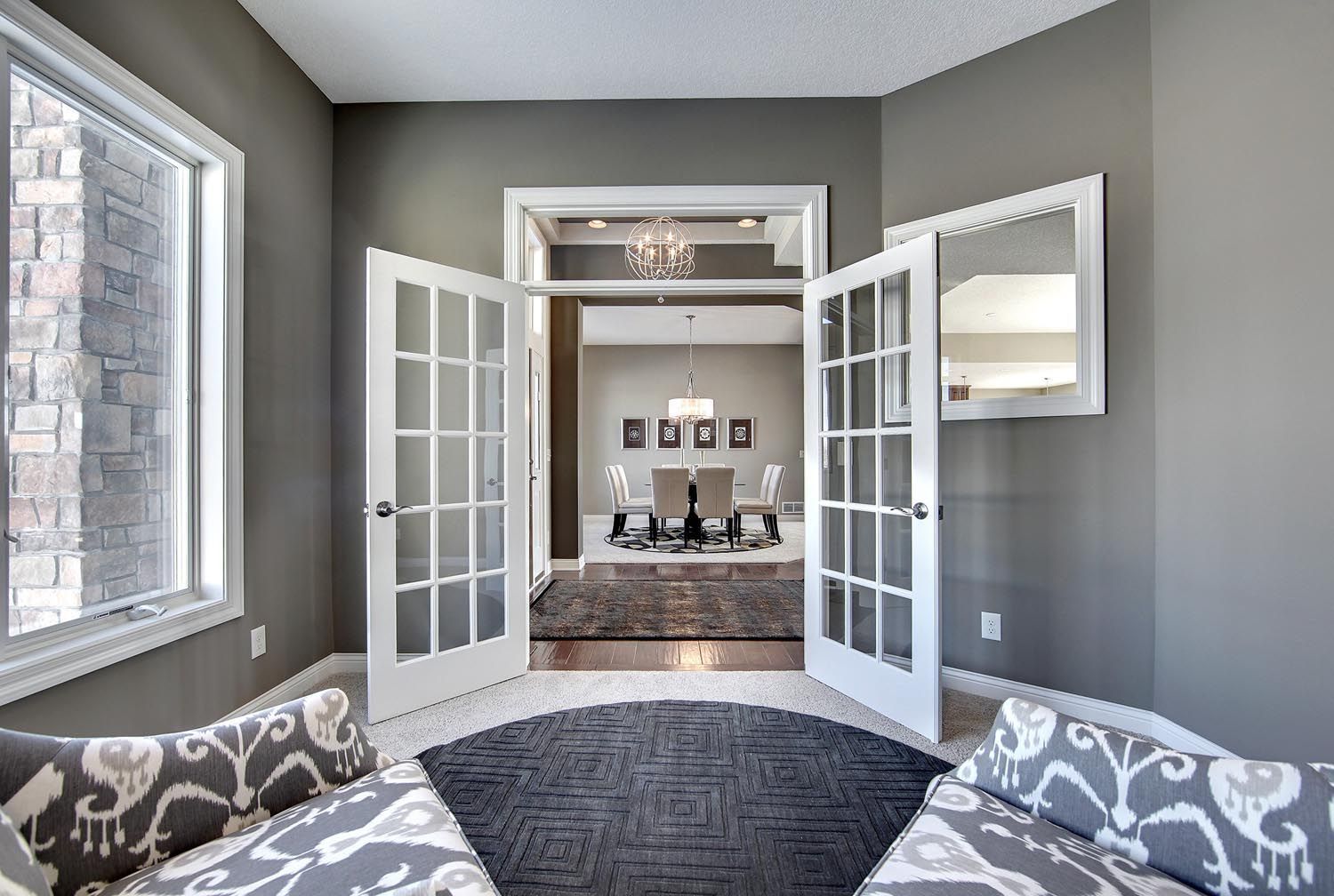 a living room with french doors leading to a dining room