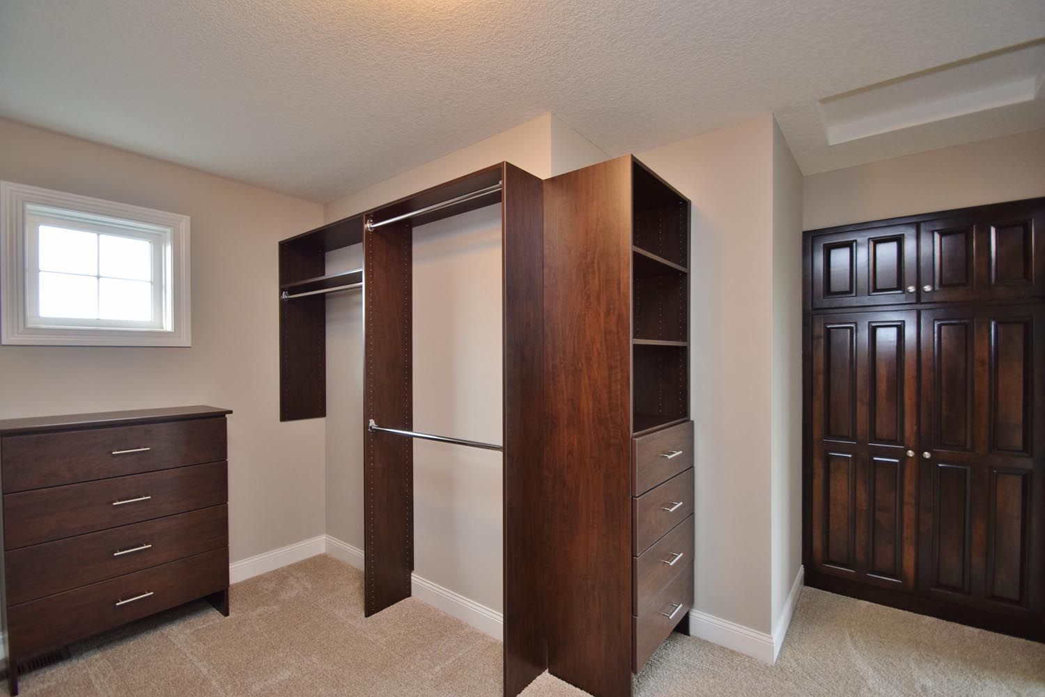 a walk in closet with a dresser and a window