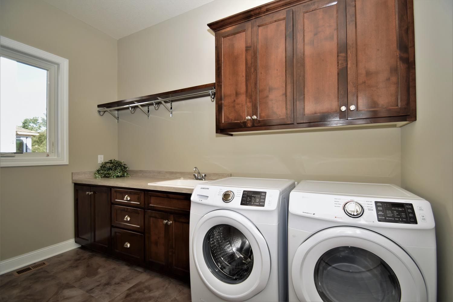 a laundry room with a washer and dryer and wooden cabinets