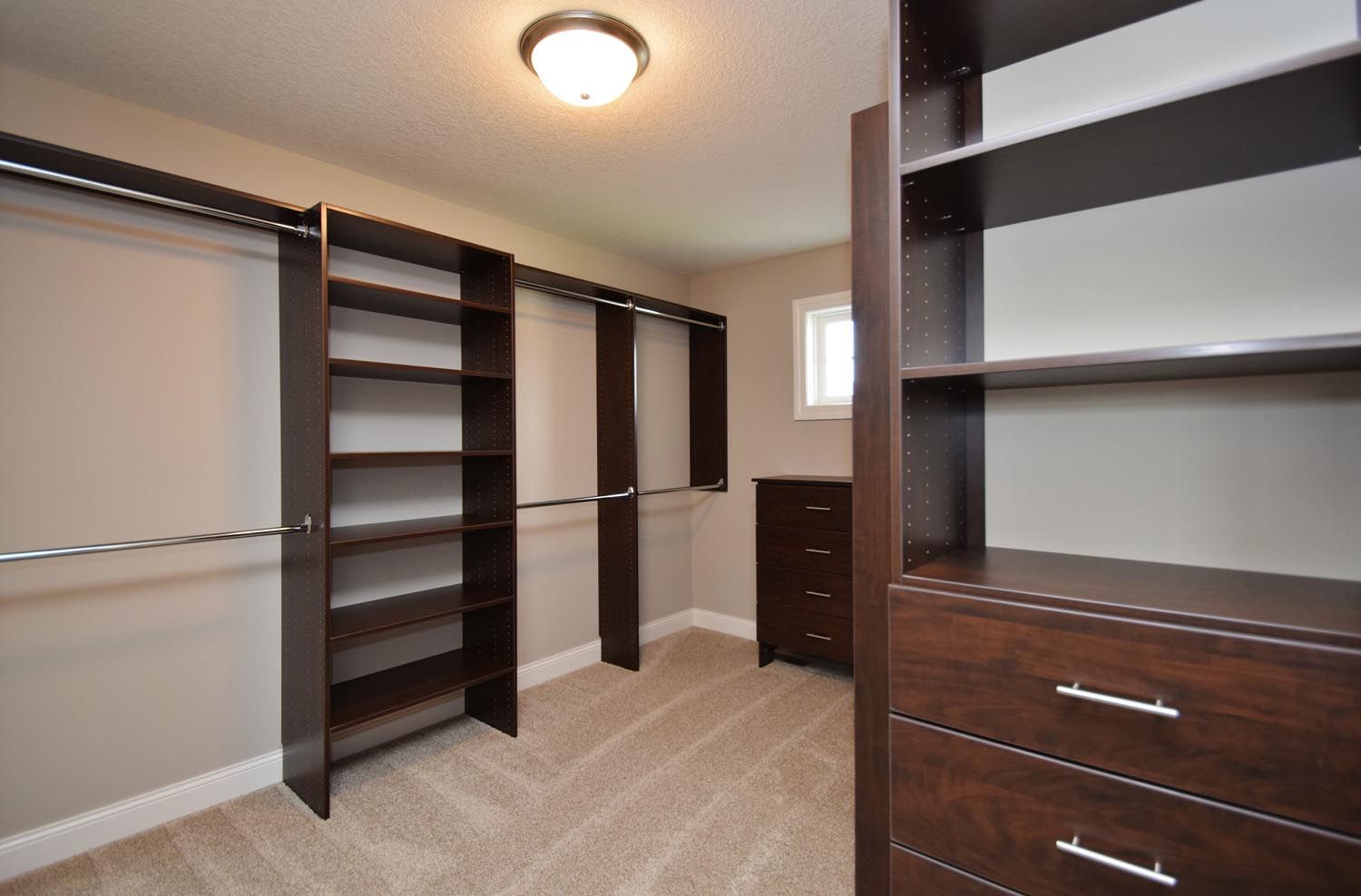 a walk in closet with lots of shelves and drawers